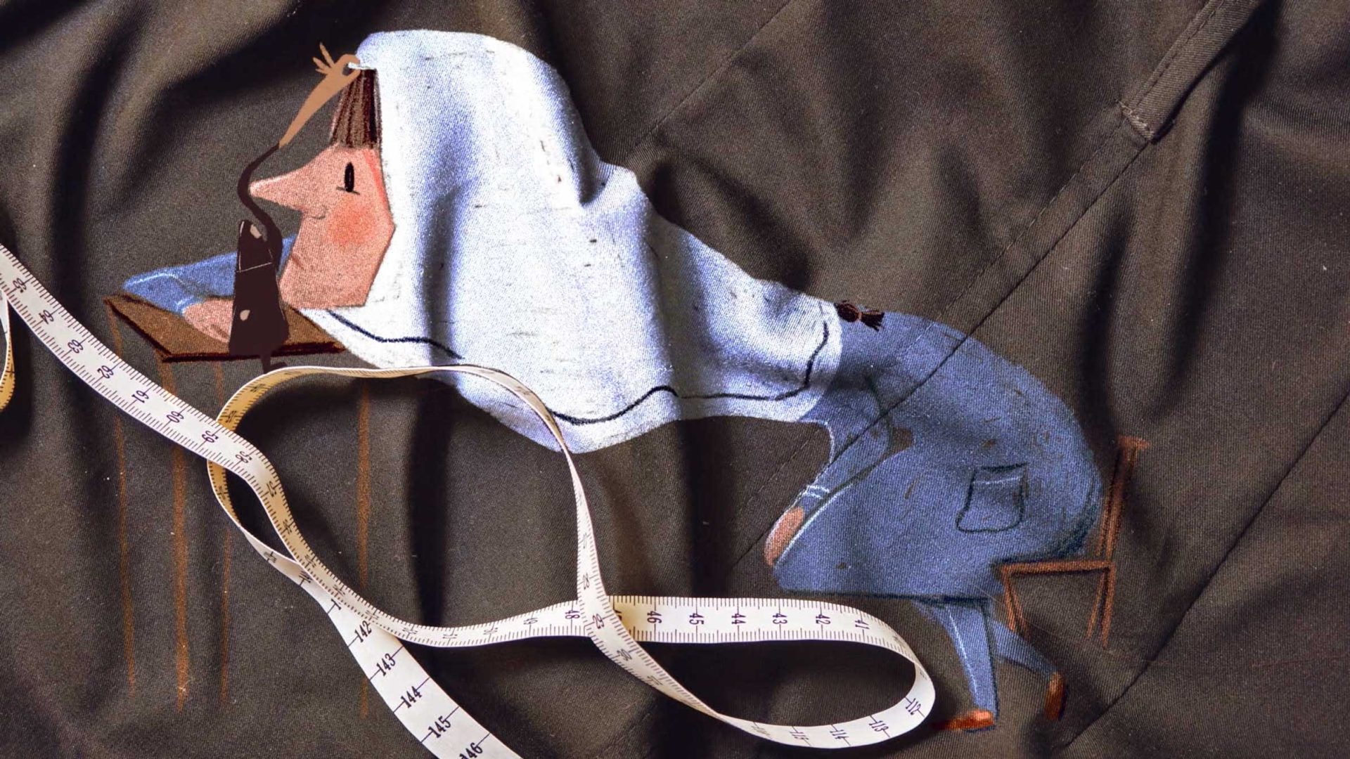 A fabric artwork by Yegane Moghaddam, titled Our Uniform, shows a person in a hooded sweatshirt leaning over a desk, appearing tired. A measuring tape lies loosely on the cloth, overlapping the person’s legs against a dark background. Frame from Stash Magazine article.