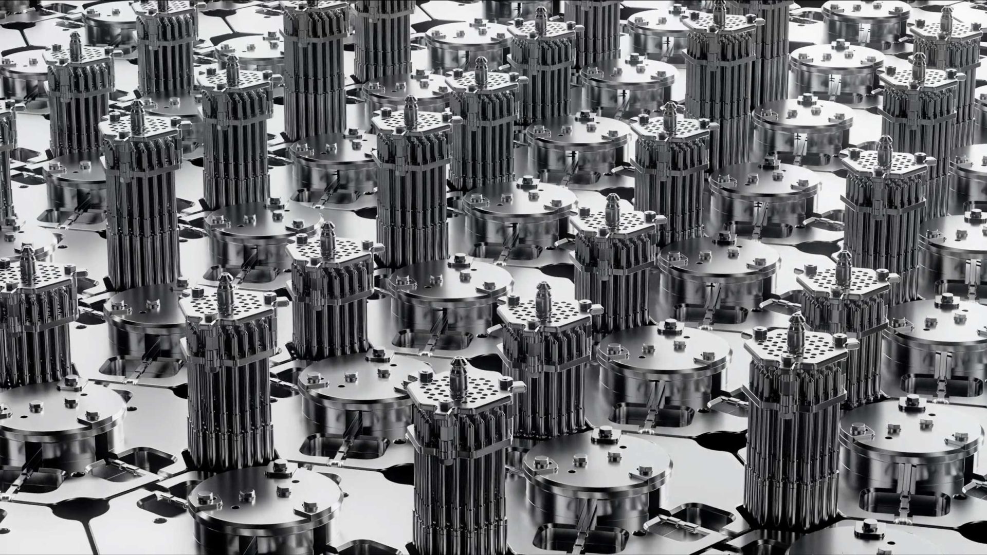 Rows of identical metallic cylindrical structures with tall, vertical fins, arranged on a reflective silver surface, create an industrial, futuristic appearance—perfectly capturing the innovative spirit of Stylo Creative’s brand film for Aalo Atomic Energy. Frame from Stash Magazine article.