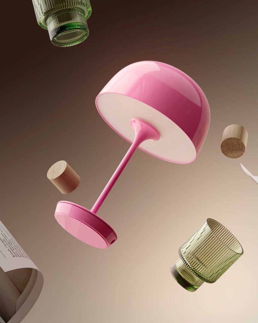 A pink modern table lamp, two green glass cups, wooden cylinders, and a magazine float against a gradient beige background, evoking the surreal, gravity-defying aesthetic of an Andreas Wannerstedt short film. Frame from Stash Magazine article.