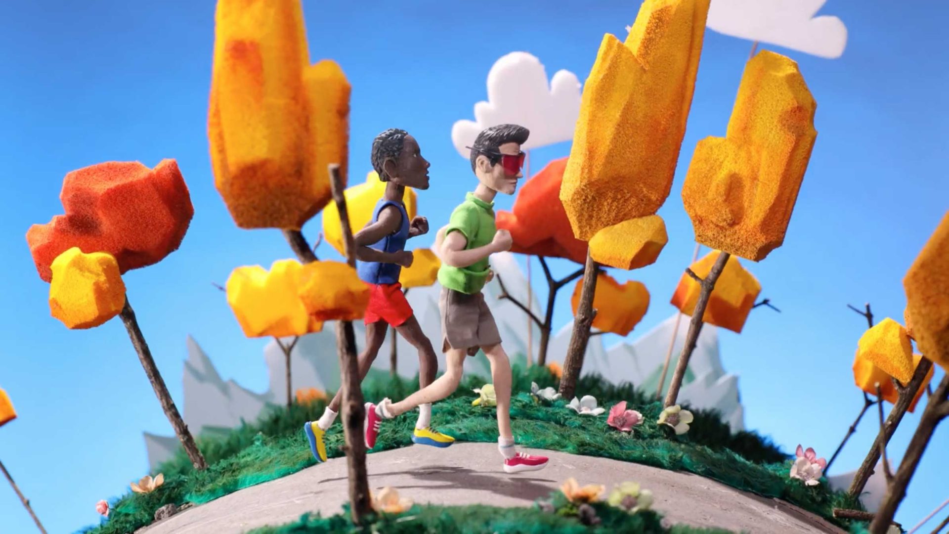 Two claymation figures participate in a Run for Mental Health along a path surrounded by stylized orange and yellow trees. Frame from Stash Magazine article.