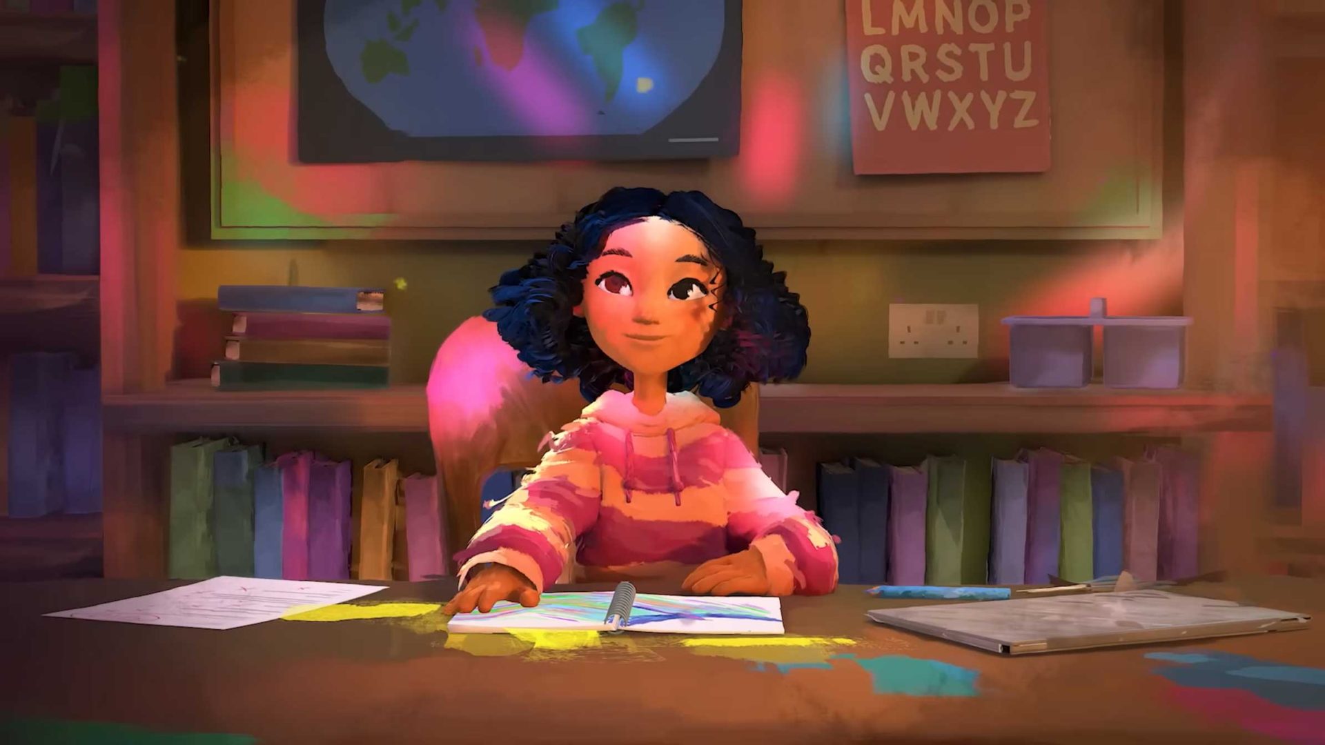 A young girl with curly hair in a colorful sweater sits at a desk drawing—a scene echoing how Art&Graft and Kyra Bartley disrupt the definition of dyslexia—surrounded by papers, books, a world map, and an alphabet chart illuminated by soft, colorful light. Frame from Stash Magazine article.