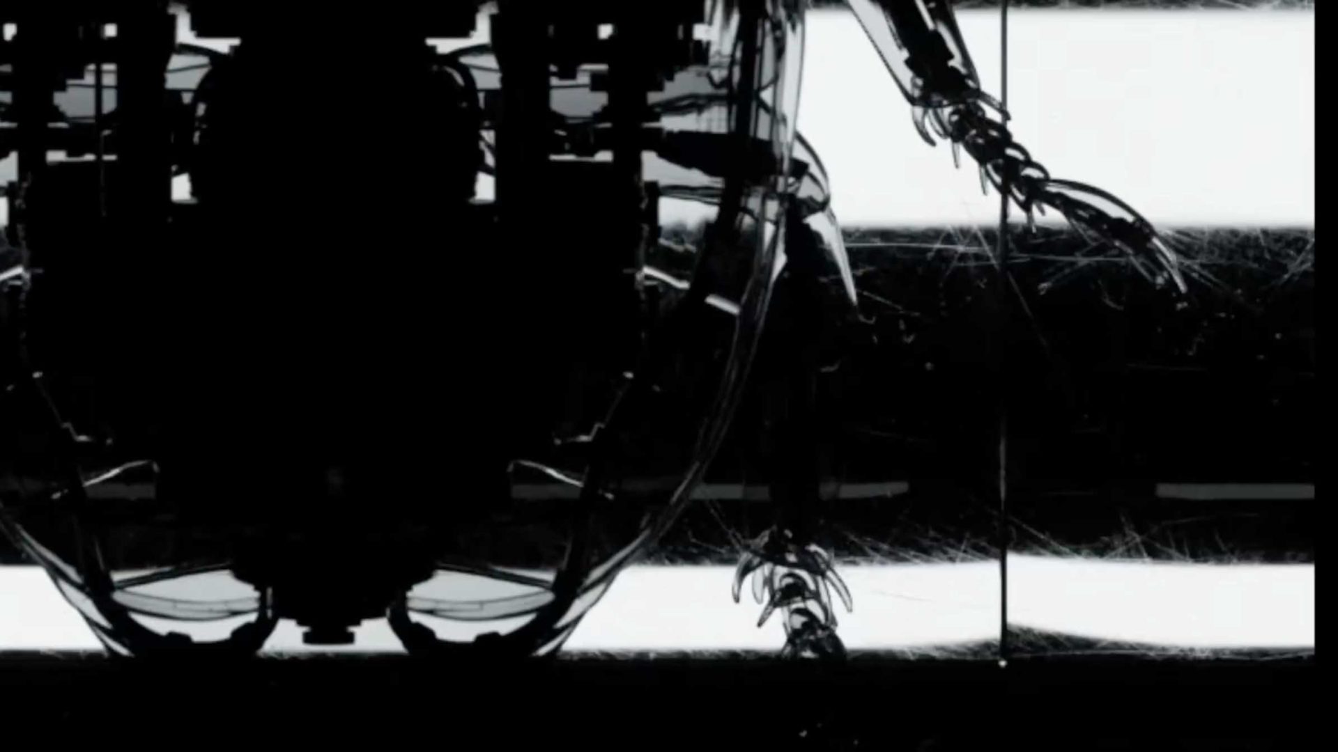 A dark, mechanical structure with cables and limbs is silhouetted against a bright, striped background in Artifex Creatura, Joan Moreno’s short film—creating a high-contrast and abstract, futuristic appearance. Frame from Stash Magazine article.