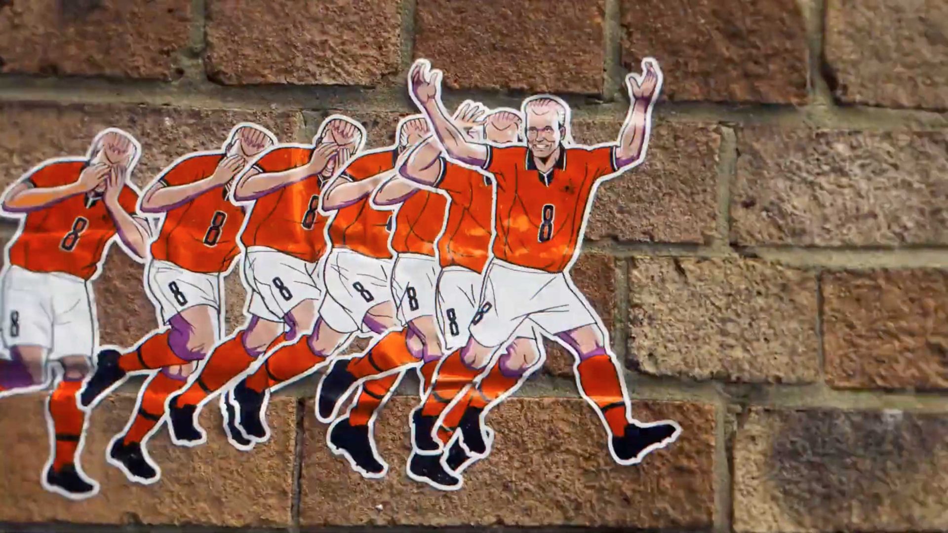 A series of cartoon soccer players in orange jerseys with the number 8, inspired by the BBC World Cup 2026 Coverage animated trailer by Nicos Livesey and Blinkink, transition from disappointment to celebration, pasted on a brick wall. Frame from Stash Magazine article.