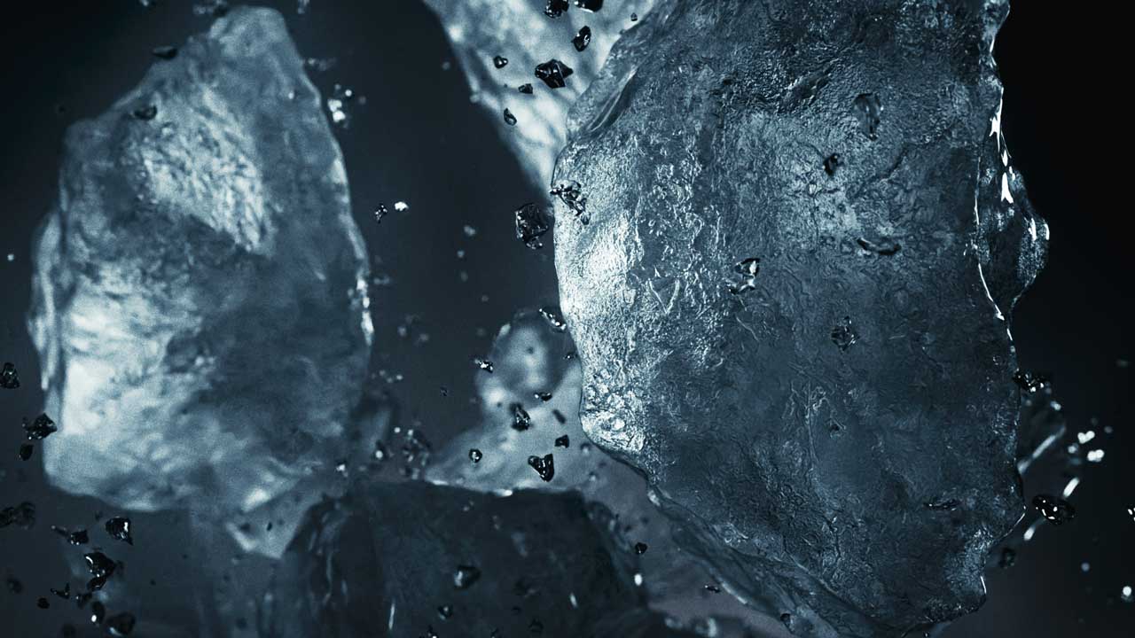 Close-up image of several irregularly shaped, translucent ice cubes with water droplets and splashes, set against a dark background. The glistening cubes evoke the chill of CCM Jetspeed skates on fresh ice. Frame from Stash Magazine article.