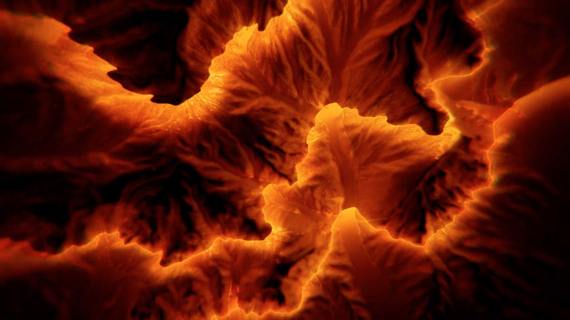 Aerial view of glowing orange and red ridges and valleys, resembling molten lava or a heated, abstract topographic map, with dramatic lighting highlighting the texture—capturing the raw essence of DEEP GEO geography through an interplay of sound & light across the landscape. Frame from Stash Magazine article.