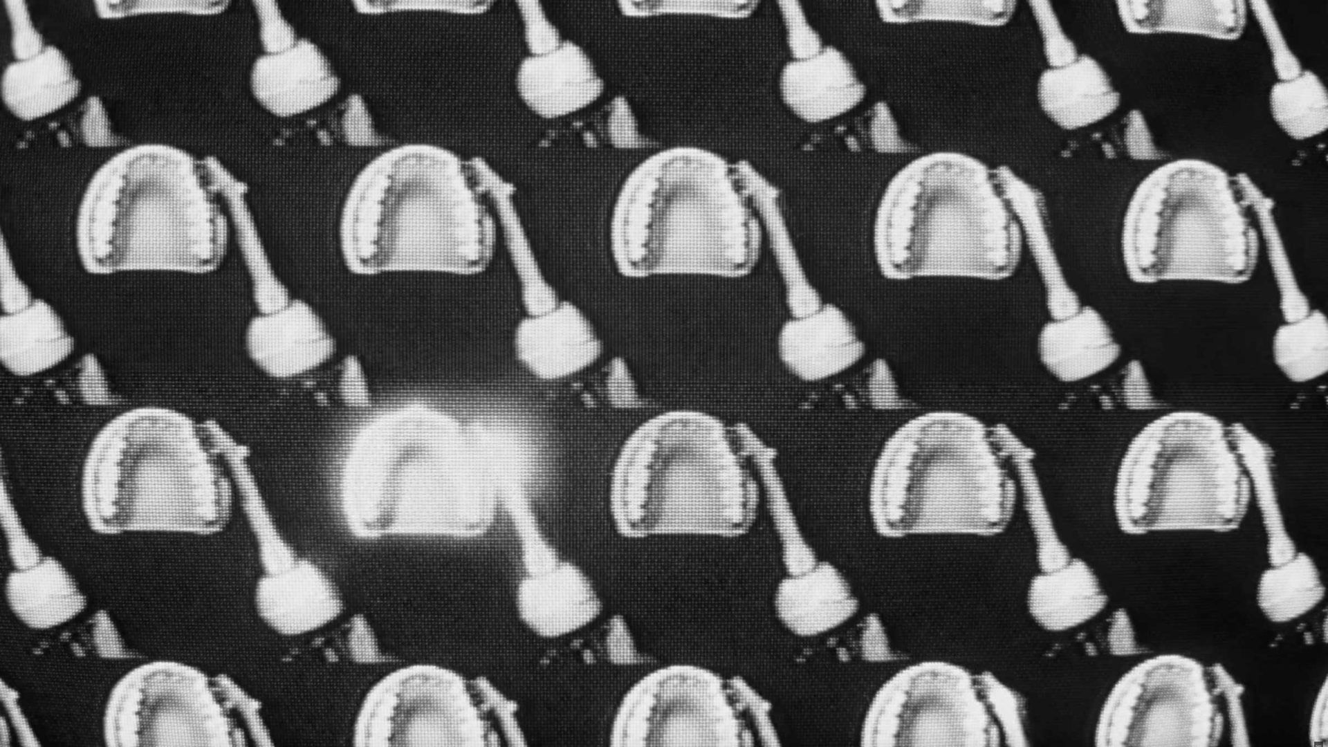 Repeating pattern of black and white dental X-rays showing open mouths and dental tools, with one X-ray highlighted by a bright white glow in the lower left quadrant, reminiscent of a scene captured with a Dyson CameraJet. Frame from Stash Magazine article.