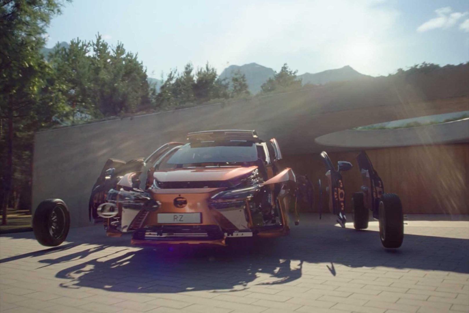 A Lexus RZ with its doors, hood, and wheels all open and detached—showcasing intricate details—appears to float around the vehicle on a sunlit driveway with trees and mountains in the background. Frame from Stash Magazine article.