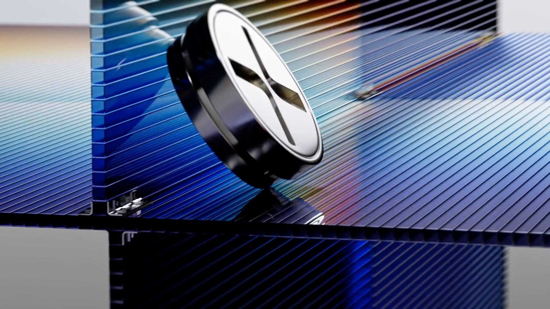 A silver coin-shaped battery rests on an intersection of blue, translucent, ribbed glass panels in the style of Felipe Pantone. Frame from Stash Magazine article.