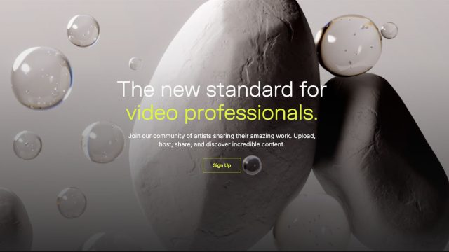 A website landing page with the text The new standard for video professionals, showcasing FrameRate as a Vimeo alternative, over a background of white stones and floating bubbles, with a highlighted Sign Up button below the text. Frame from Stash Magazine article.