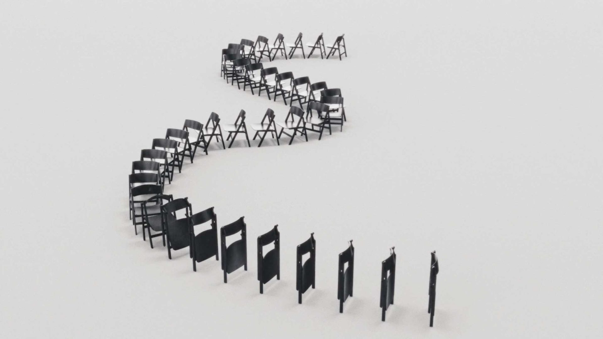 Black folding chairs from HAY are arranged in a winding, S-shaped FRAME on a plain white background, showcasing the charm of chairs in a visually striking and minimalist composition. Frame from Stash Magazine article.