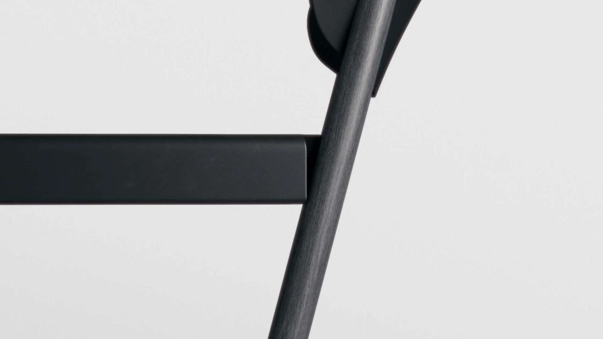 Close-up view of a black HAY folding chair against a plain light gray background, focusing on the chair’s FRAME and backrest. Frame from Stash Magazine article.