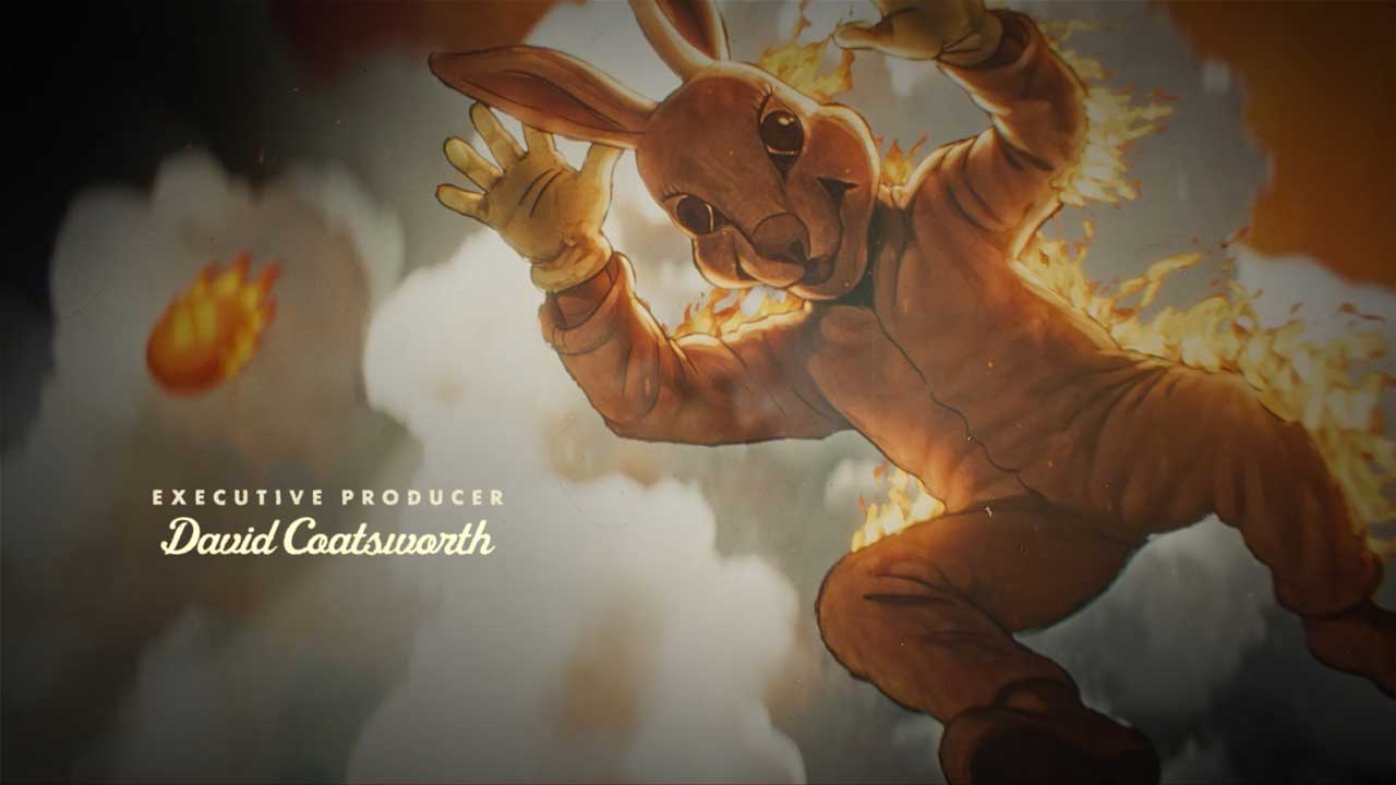 A person in a large brown rabbit costume is on fire, flames leaping from the suit as smoke swirls behind. The text Executive Producer David Coatsworth appears on the left, echoing the surreal style of IT: Welcome to Derry fantasy titles by Filmograph. Frame from Stash Magazine article.