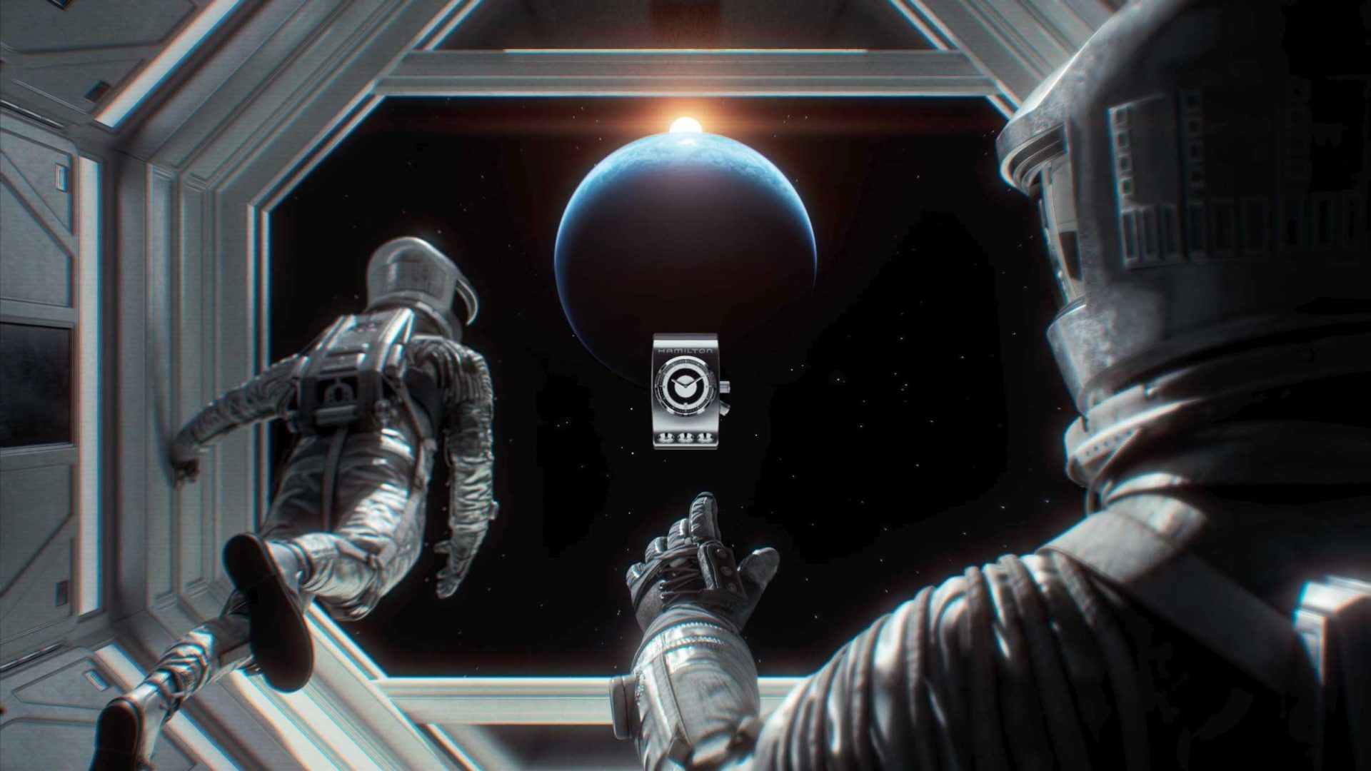 Two astronauts in spacesuits look out from a spacecraft at Earth and a bright sunrise, while a futuristic device floats between them—an inspiring scene reminiscent of a Hamilton brand film crafted by Kutuko. Frame from Stash Magazine article.