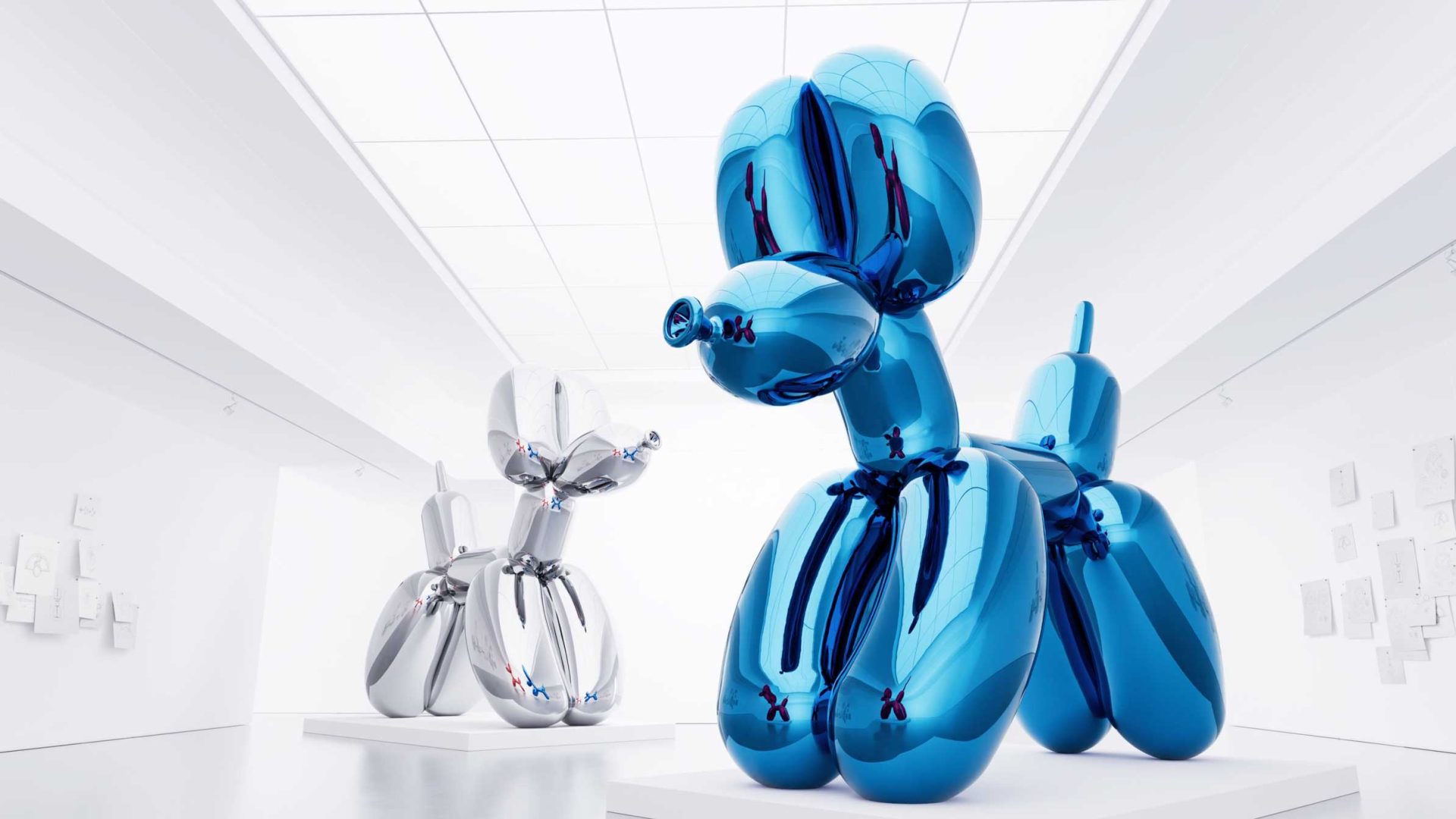 Large blue and silver metallic balloon dog sculptures, reminiscent of Jeff Koons’ iconic style, are displayed in a bright, modern white gallery with artwork on the walls and a grid skylight ceiling—an environment that perfectly complements the playful sophistication of the Classic Fusion Balloon Dog collaboration with Hublot. Frame from Stash Magazine article.