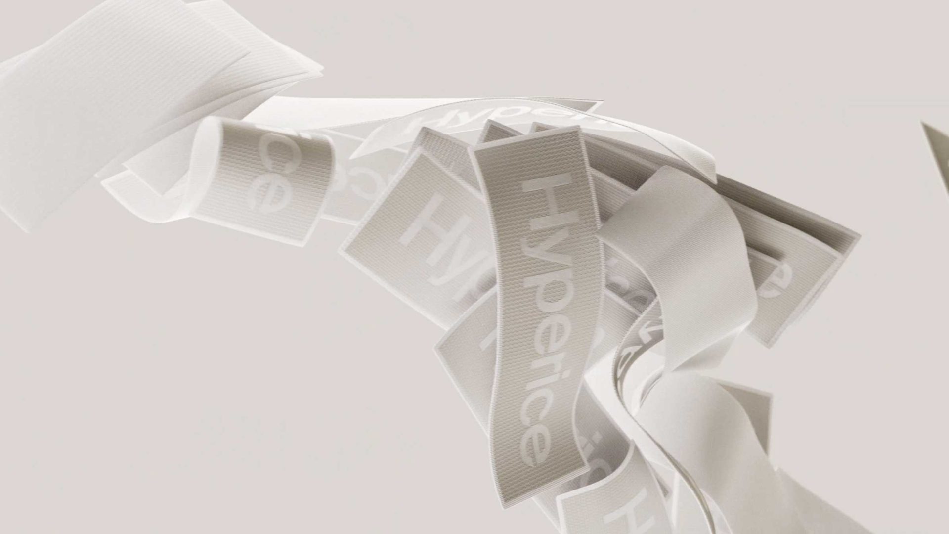 White fabric ribbons branded with the Hyperice logo float in the air, captured in the Hyperslide launch film for Hyperice and Nike. Frame from Stash Magazine article.