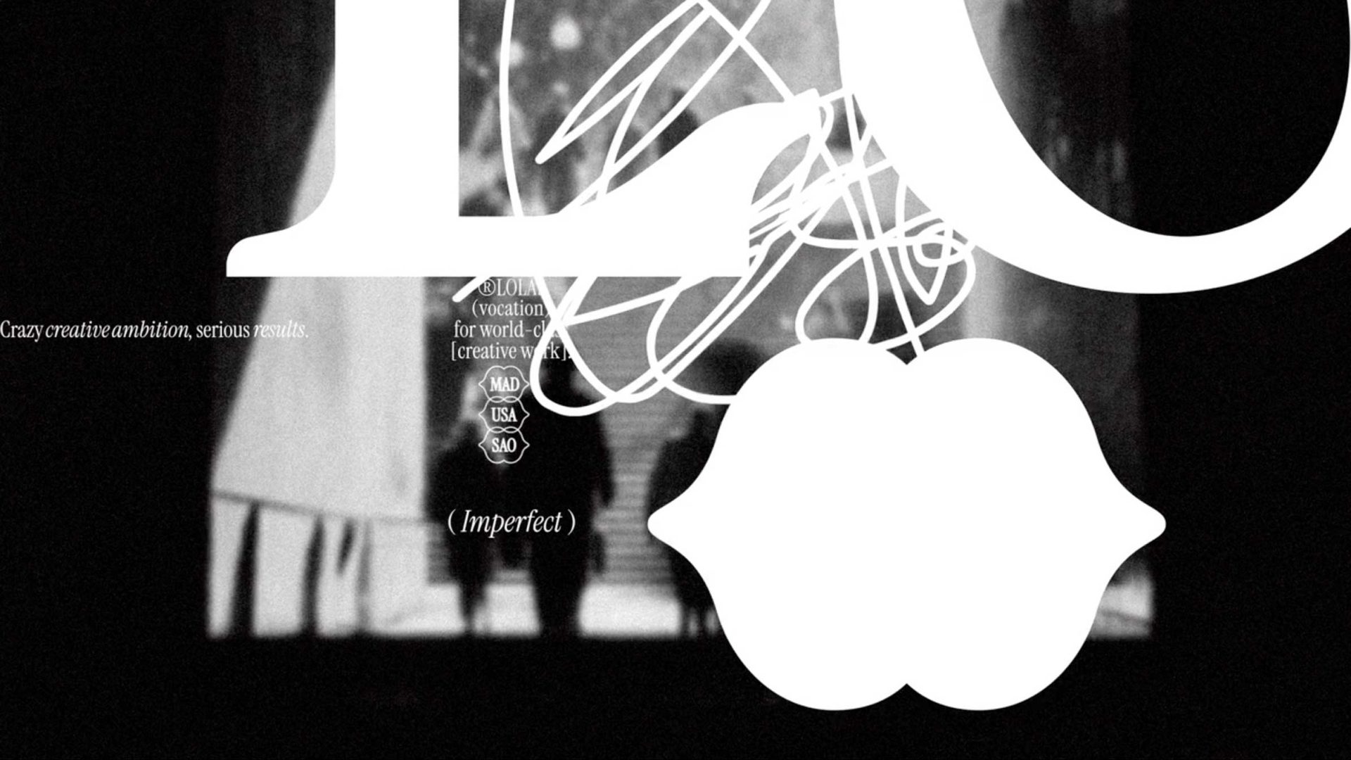 Abstract black-and-white image with large white letters, scribbles, and a citrus shape overlaying blurred silhouettes—evoking a David Carson-inspired aesthetic. Text reads: Crazy creative ambition, serious results. and (Imperfect). Perfect for a bold Brand Refresh or innovative campaigns with LOLA Global. Frame from Stash Magazine article.