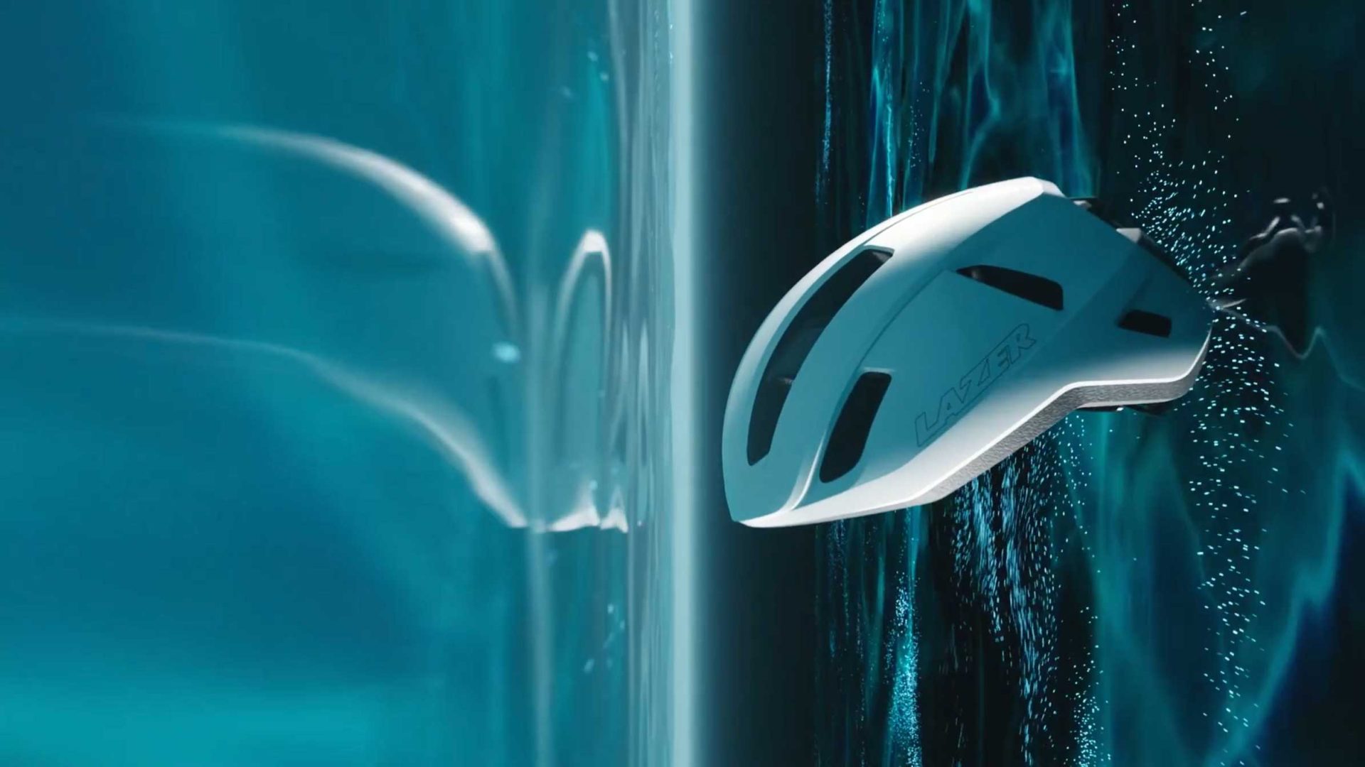 A white Lazer cycling helmet with “Lazer” branding hovers next to a reflective blue surface, creating a clear mirror image. The dynamic background, inspired by Hell & High Water, features vivid blue lighting and water droplets. Frame from Stash Magazine article.