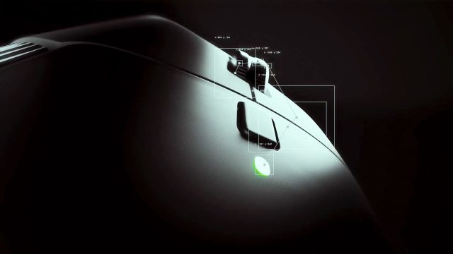 Close-up of a black Logitec MX Master 4 mouse in low light, highlighting its scroll wheel and side buttons. A small green LED indicator is lit near the thumb button, with white data overlays showing detailed measurements. Frame from Stash Magazine article.