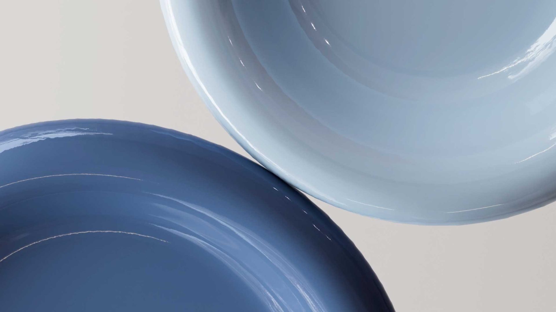 Two ceramic plates, one light blue and one darker blue, are placed next to each other on a light surface, viewed from above—a composition that echoes the refined aesthetic seen in MADE Design at Play brand film by Miles Hellyer & Chalk Company. Frame from Stash Magazine article.