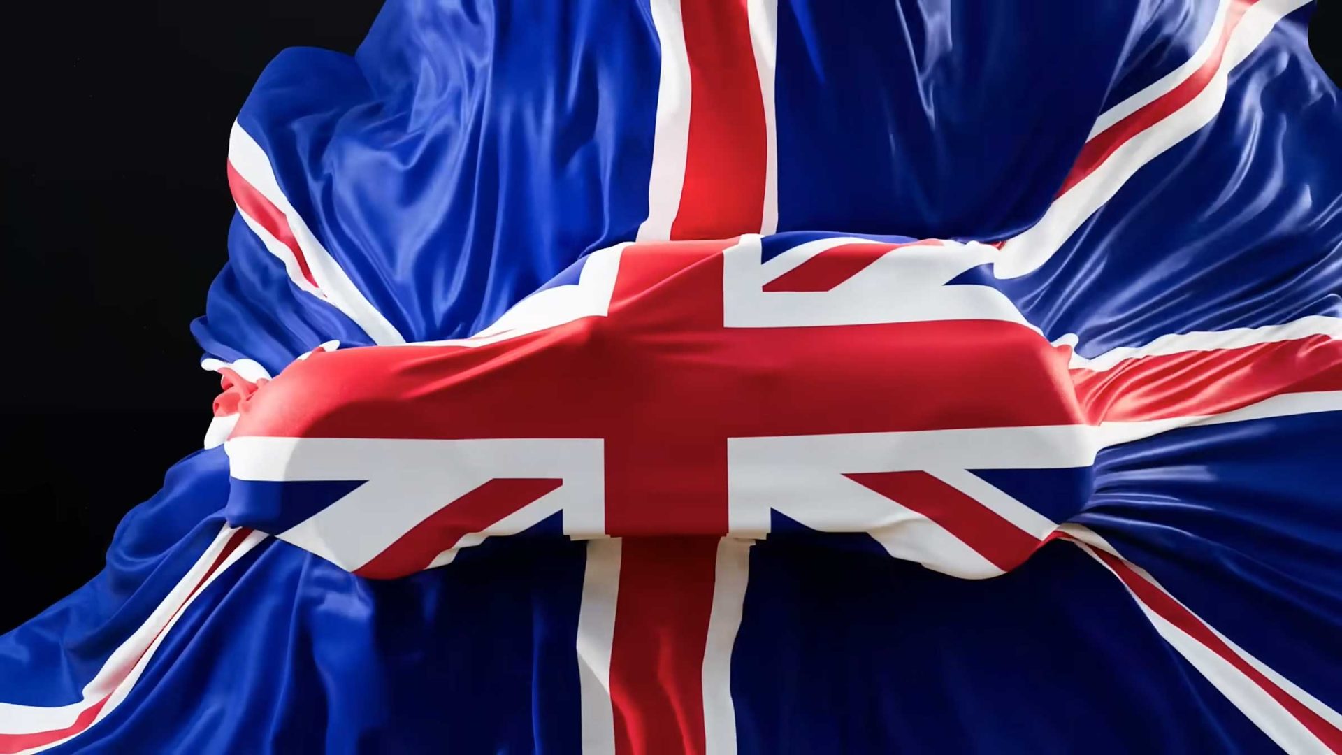 A close-up of the Union Jack flag draped and gathered in the center, creating folds and creases, evokes the spirit of MINI Icon Drops Special Editions, set against a dark background. Frame from Stash Magazine article.