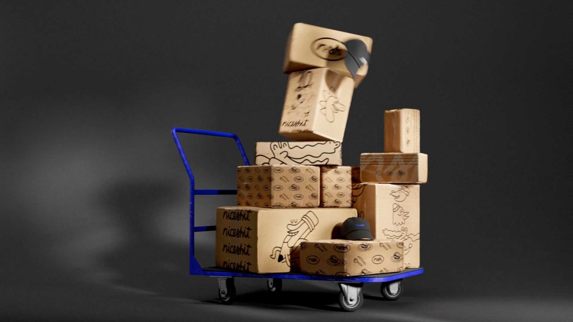 A blue hand truck loaded with several cardboard boxes, some decorated with doodles and patterns, against a plain dark background. One box is tipping or falling from the top of the stack. Frame from Stash Magazine article.