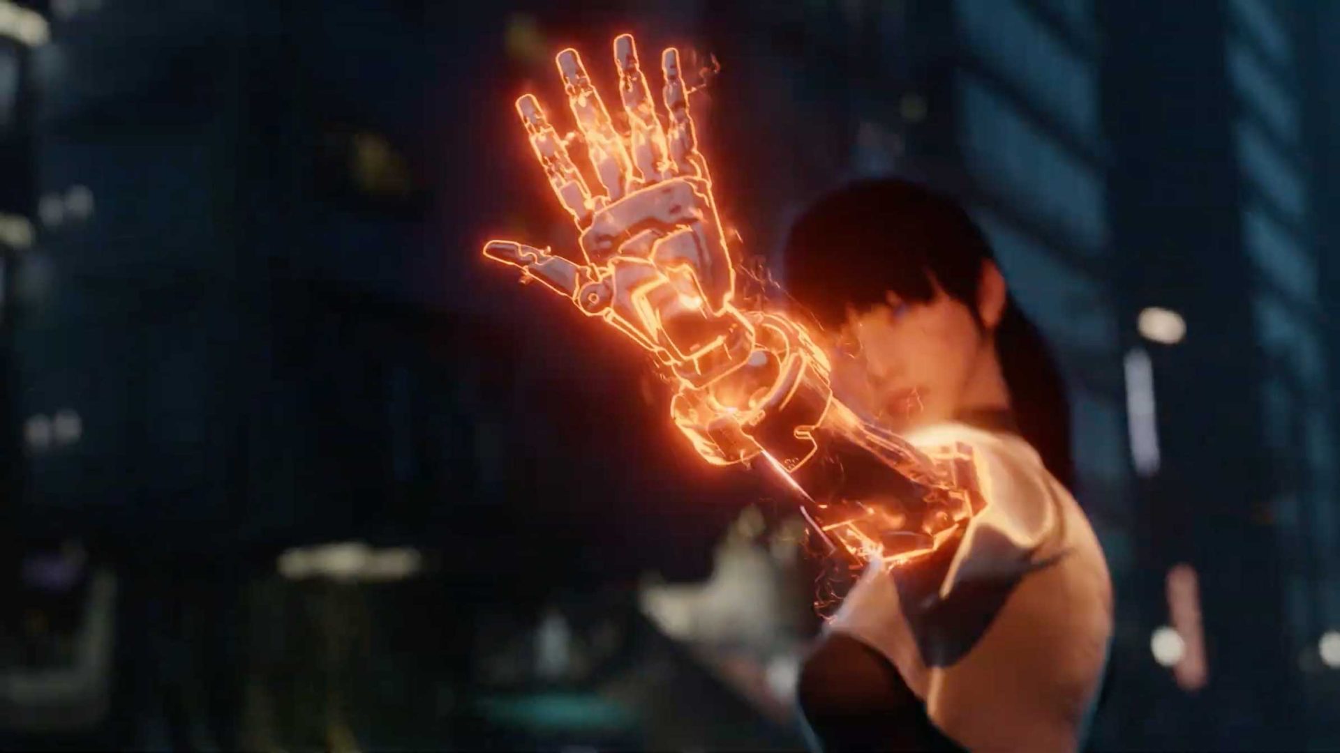 A woman stands in a city at night, holding up a glowing, orange robotic arm with energy radiating from it. Her face is mostly visible, and she appears to be bracing for action in this tense scene from OUTLAW Short Film’s Girl vs Robot series. Frame from Stash Magazine article.