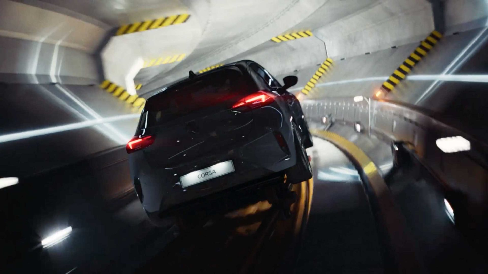 A dark grey Opel car marked “CORSA” speeds through a futuristic, curved tunnel with glowing lines and yellow hazard stripes on the walls—an environment that feels almost mathematic in its precision. Frame from Stash Magazine article.