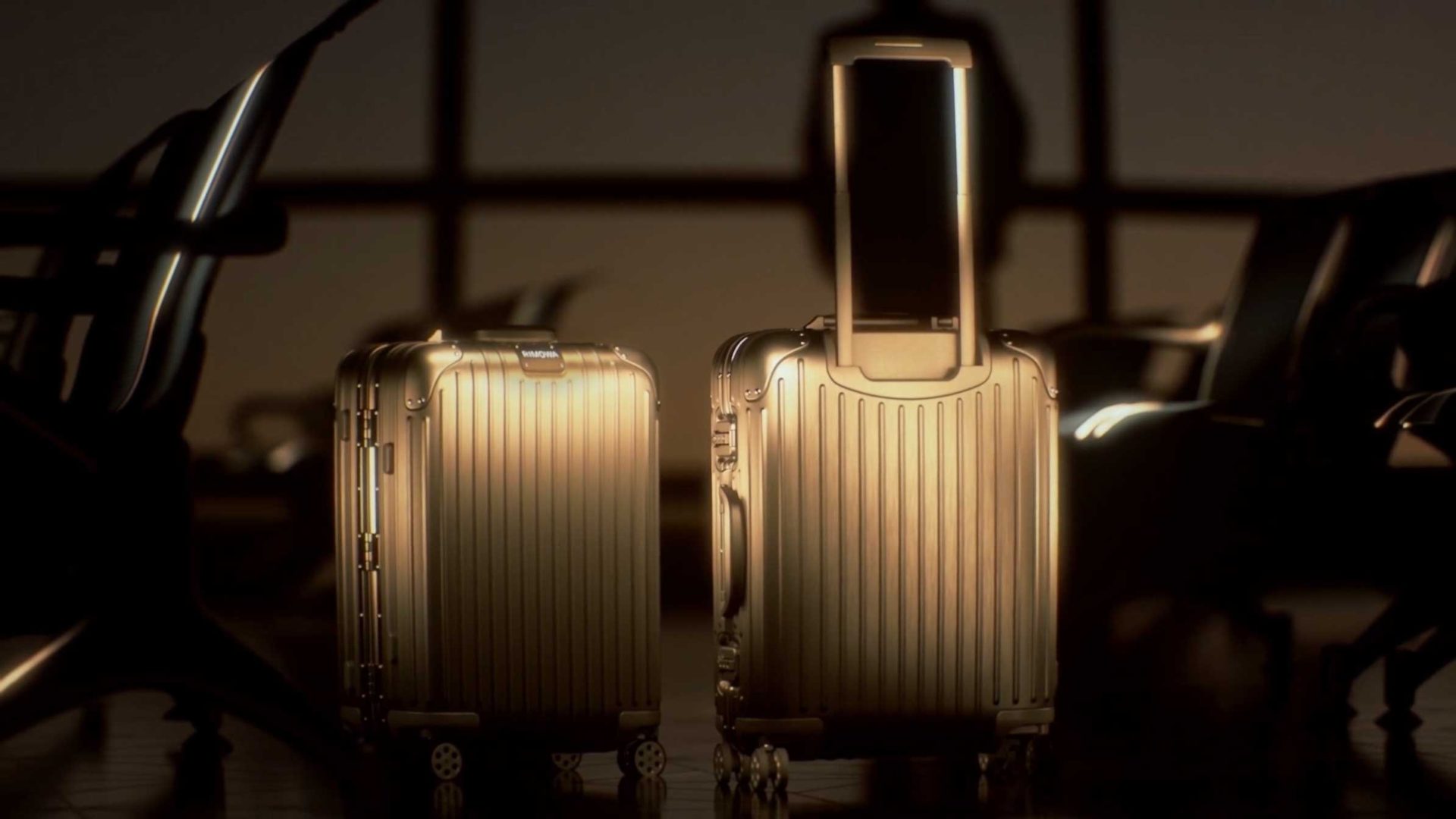 Two metallic gold RIMOWA suitcases stand side by side in an airport waiting area, illuminated by warm light, with empty chairs and a silhouetted figure in the background—reflecting true precision in motion for modern travelers. Frame from Stash Magazine article.