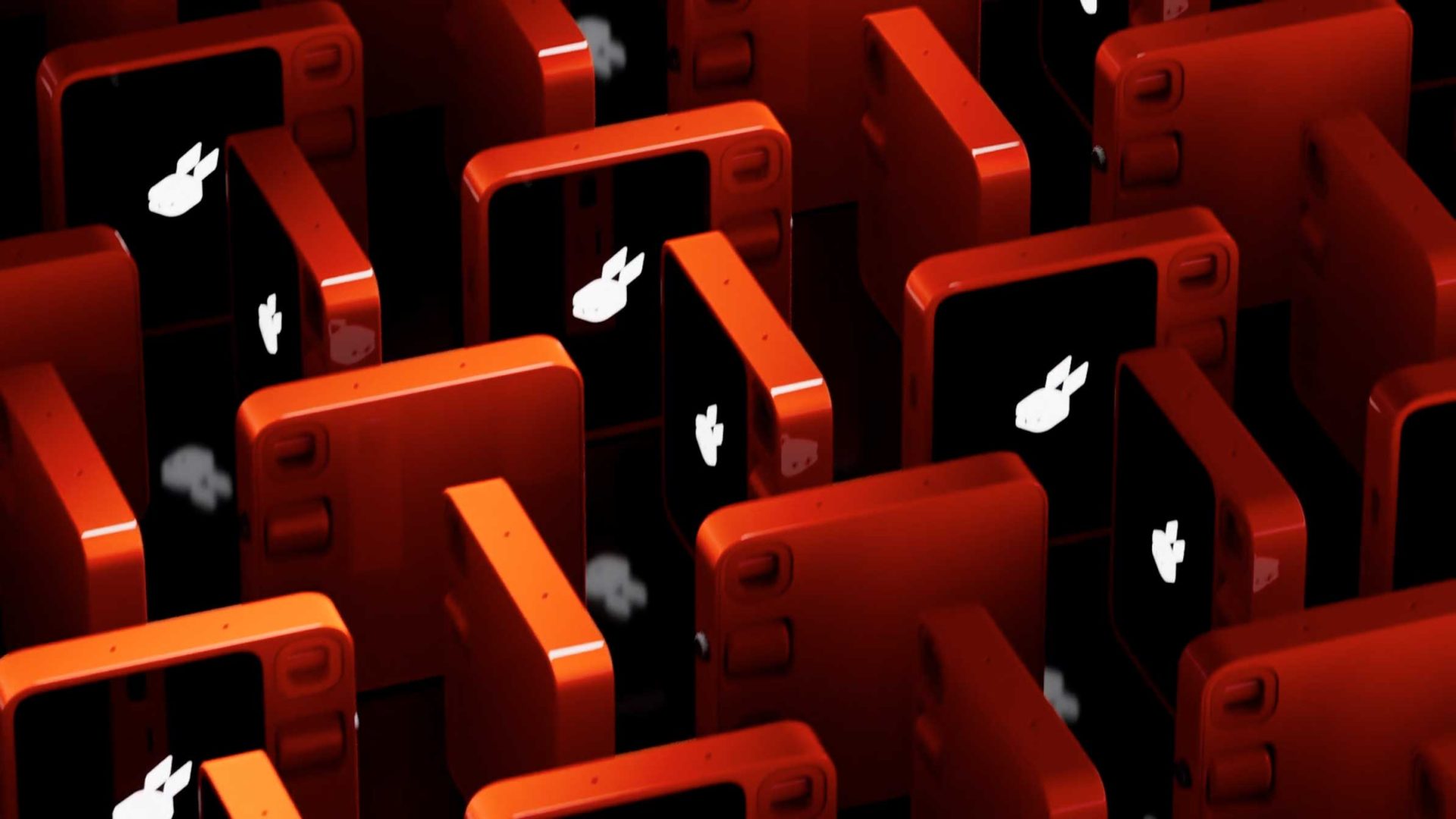 Rows of red Rabbit r1 smartphones are arranged closely together, all displaying a white bunny icon on their screens against a black background. The composition creates a repeating, geometric pattern reminiscent of a product film styleframe. Frame from Stash Magazine article.