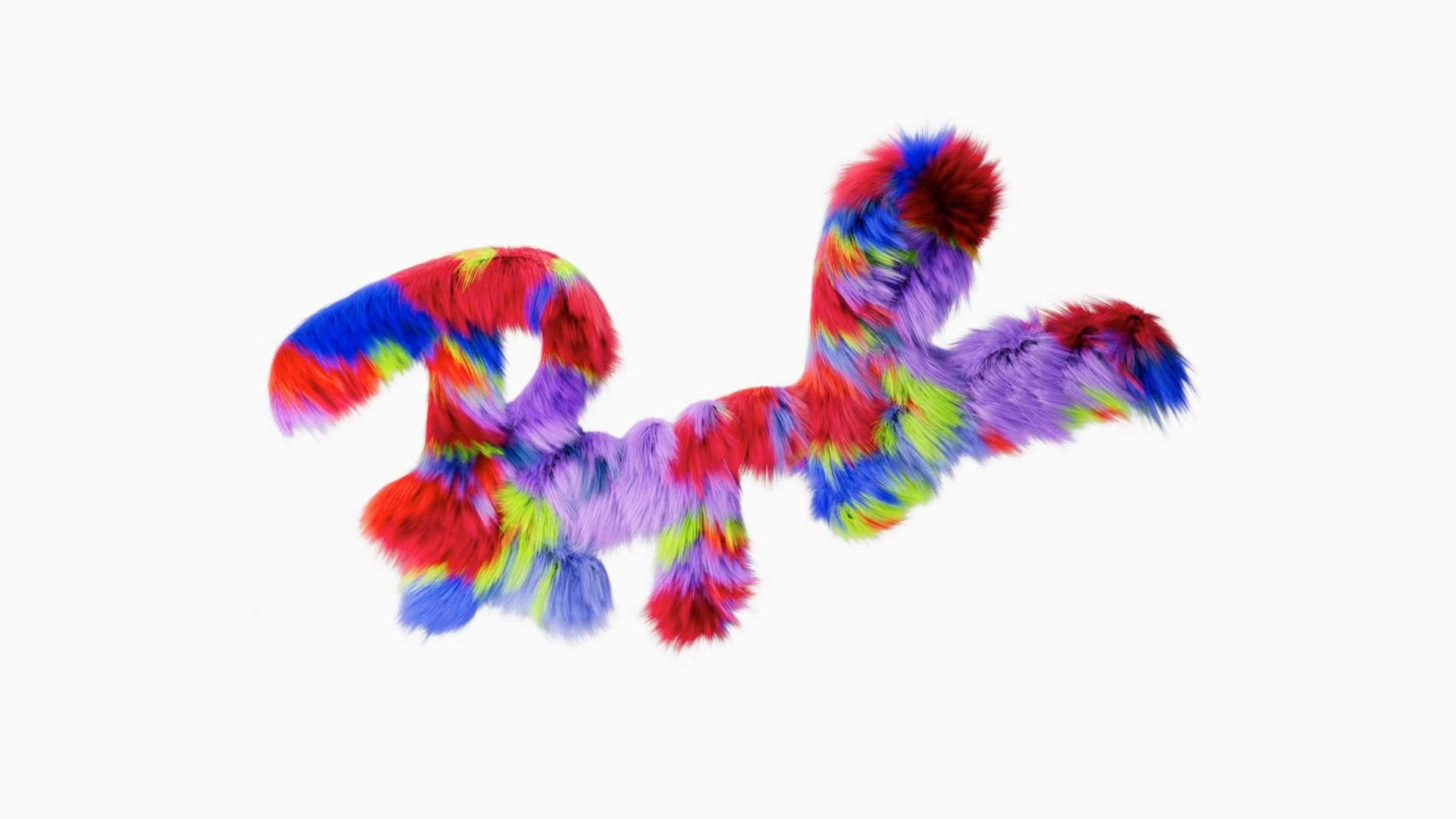 A fluffy, abstract shape covered in vibrant red, blue, yellow, green, and purple fur stands out against a plain white background—its playful energy reminiscent of Ray-Ban Kids’ bold style. Frame from Stash Magazine article.