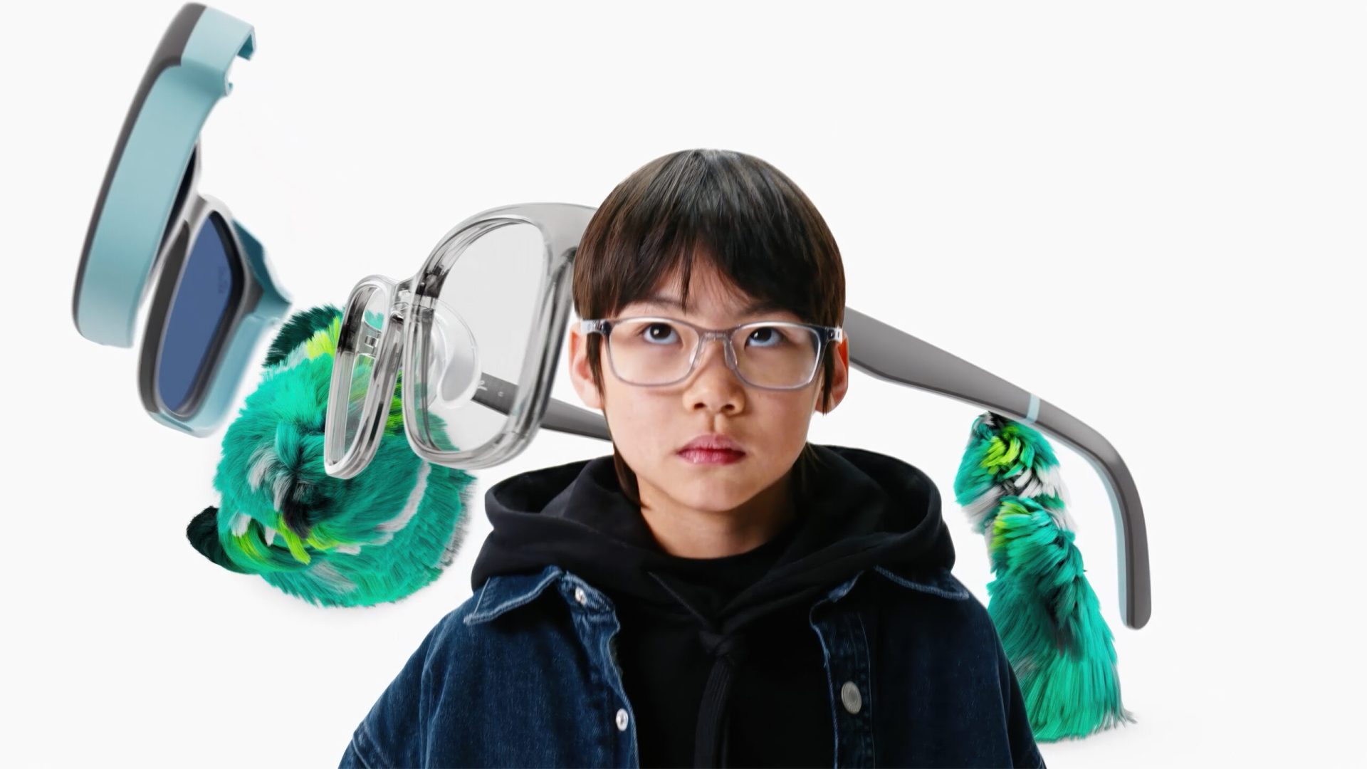 A child wearing glasses and a hoodie stands in front of oversized, floating eyeglasses and green feathered shapes, with a white background—an imaginative scene inspired by the Ray-Ban Kids Campaign by Ditroit and C41 | STASH MAGAZINE7. Frame from Stash Magazine article.