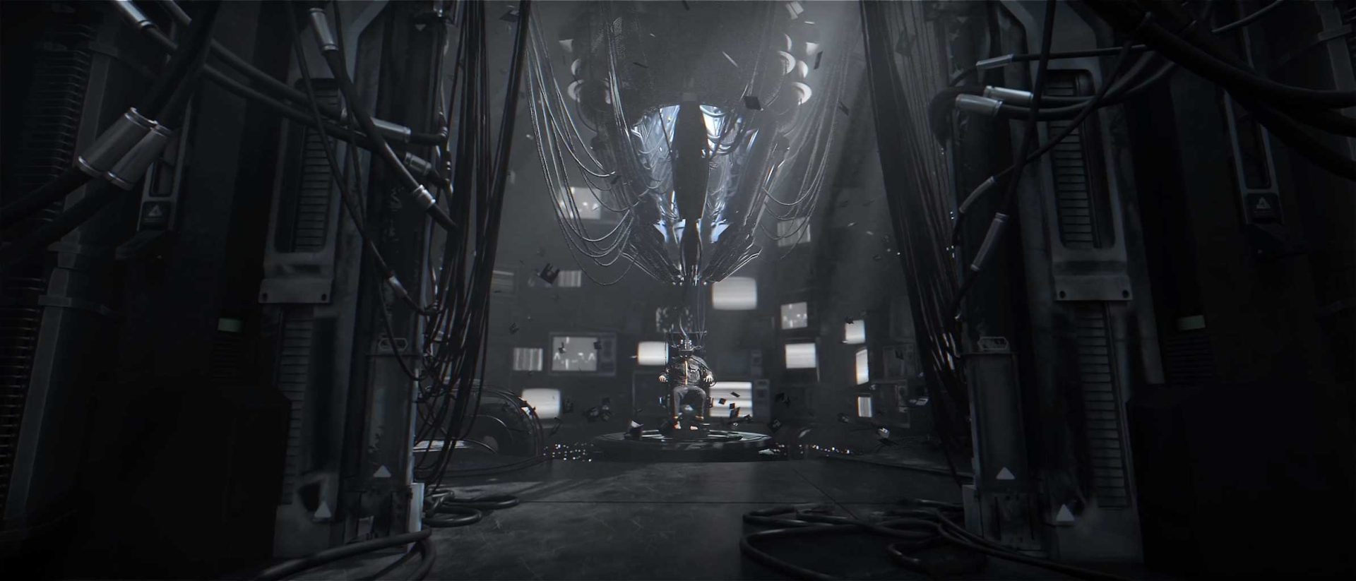 A dark, futuristic room filled with cables and monitors, featuring a suspended metallic structure in the center surrounded by glowing screens and industrial machinery—this is the evocative setting for Jeongmin Seo’s short film “Reminder.”. Frame from Stash Magazine article.