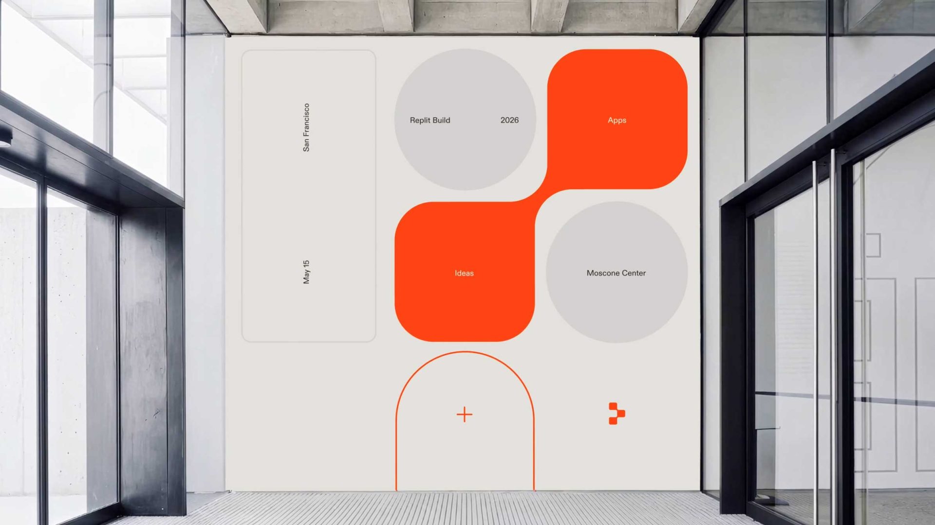 A modern wall graphic with geometric shapes in gray and orange, inspired by the Replit Brand Film by Oddfellows, features labeled sections: Replit Build, Apps, Ideas, Moscow Center, and the date May 19. The design remains minimal and abstract. Frame from Stash Magazine article.