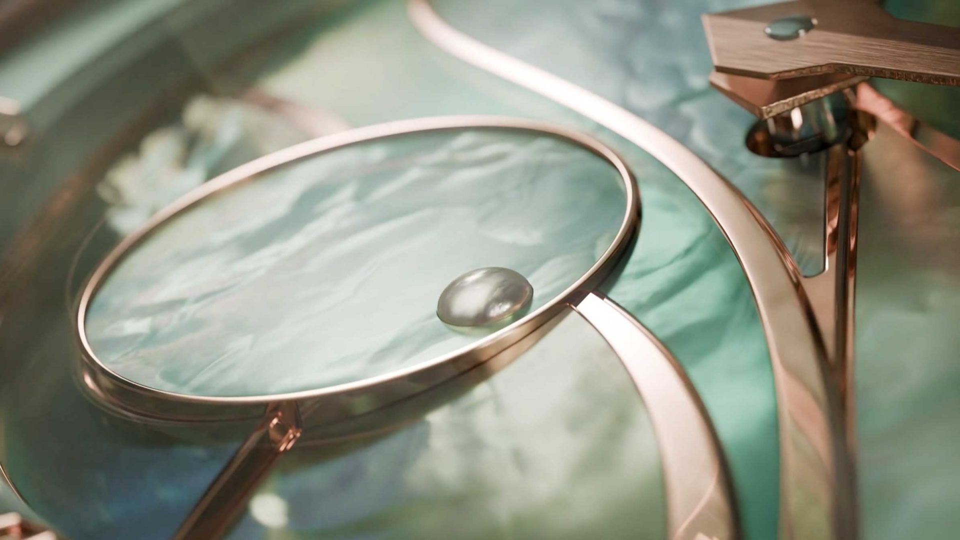 A close-up of the Roger Dubuis Lady of the Lake watch launch by le truc, showcasing an elegant clock face with gold details, a glass magnifying lens, and a droplet on turquoise marble, highlighting reflections and luxurious textures. Frame from Stash Magazine article.