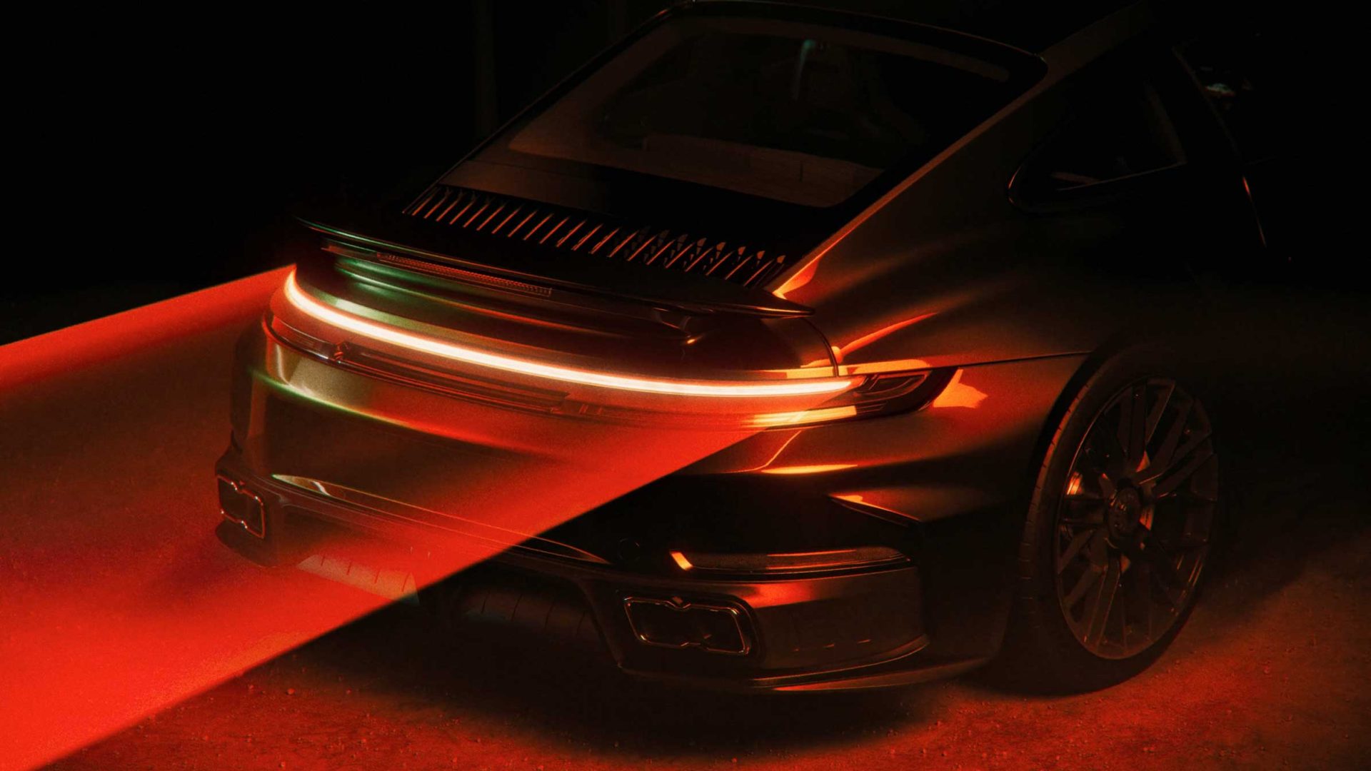 A sleek black sports car is shown from the rear, illuminated by dramatic red lighting in this SAGA studio launch film. The taillights create a bright horizontal line, with red light beams projecting onto the ground behind the car. Frame from Stash Magazine article.