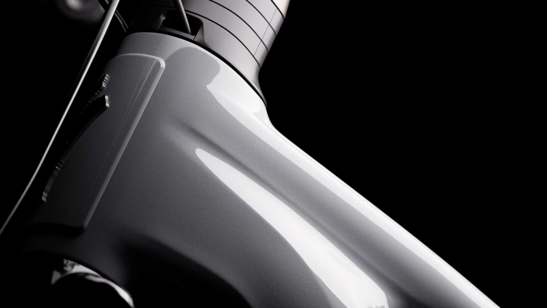 Close-up of a sleek, glossy white bicycle frame—reminiscent of the cutting-edge design seen in the Specialized Vado 3—set against a black background, highlighting smooth curves and minimalist style that evoke a sense of dynamic inertia ready for launch. Frame from Stash Magazine article.
