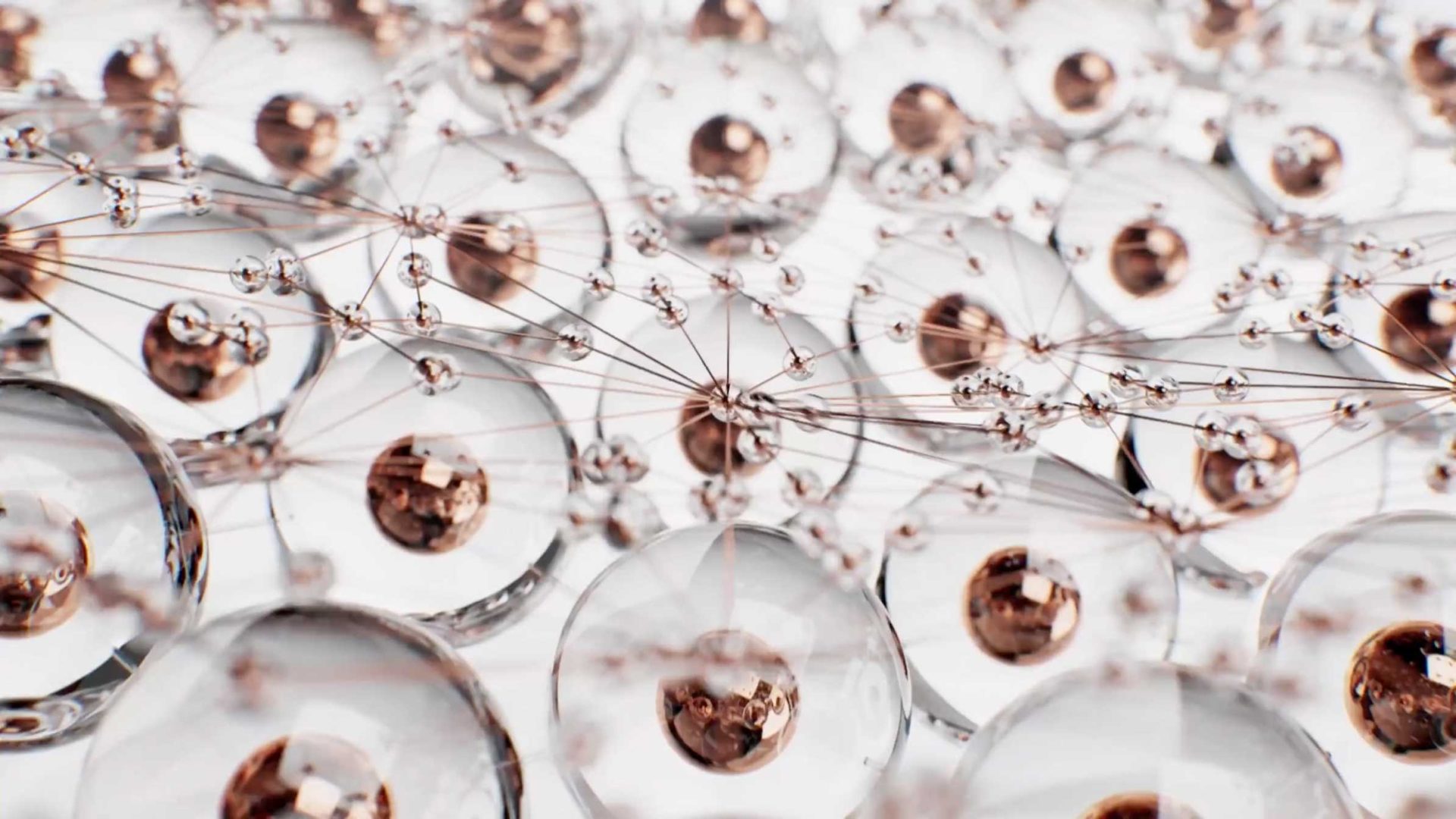 A close-up view of interconnected transparent spheres with copper-colored centers, linked by thin, delicate lines, resembling a network or molecular structure on a white background. Frame from Stash Magazine article.