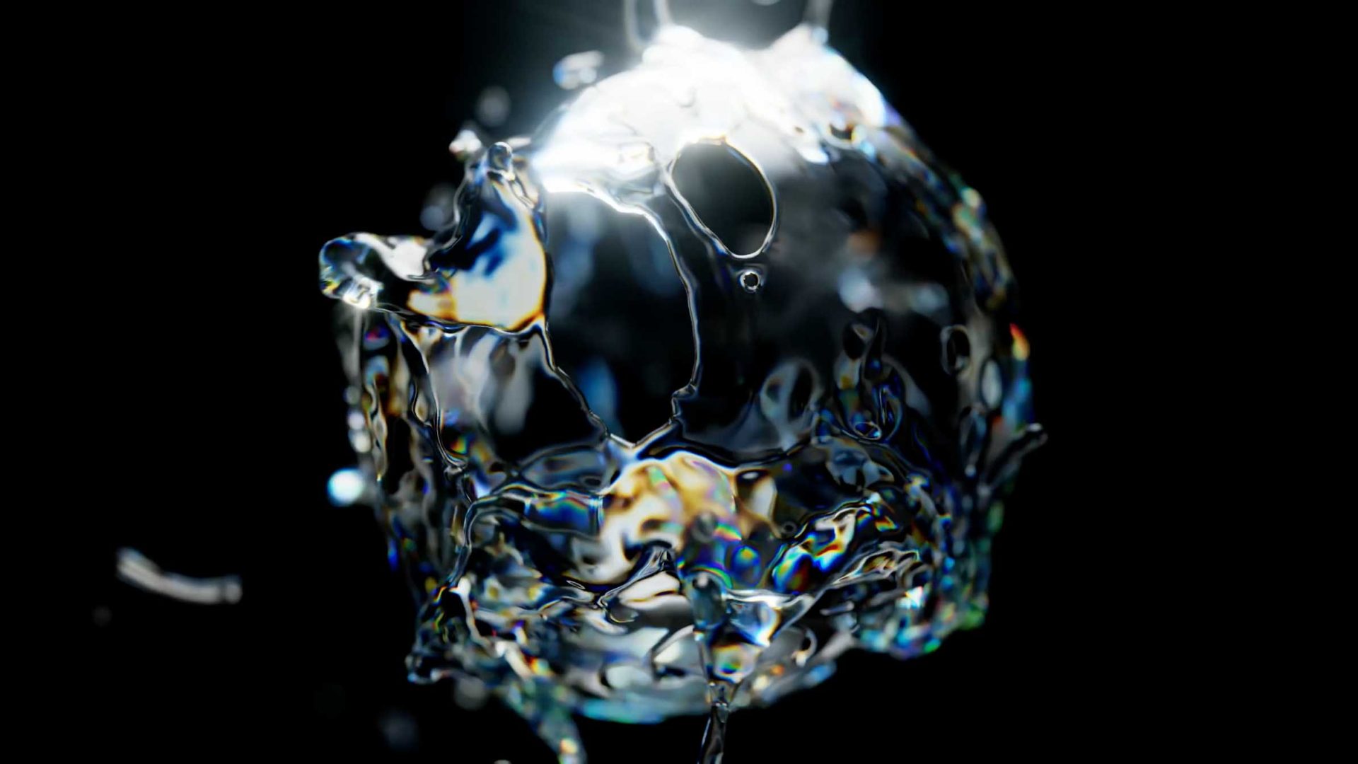 A shiny, abstract, spherical splash of clear liquid is suspended against a dark background, reflecting light and subtle rainbow-like colors. Frame from Stash Magazine article.