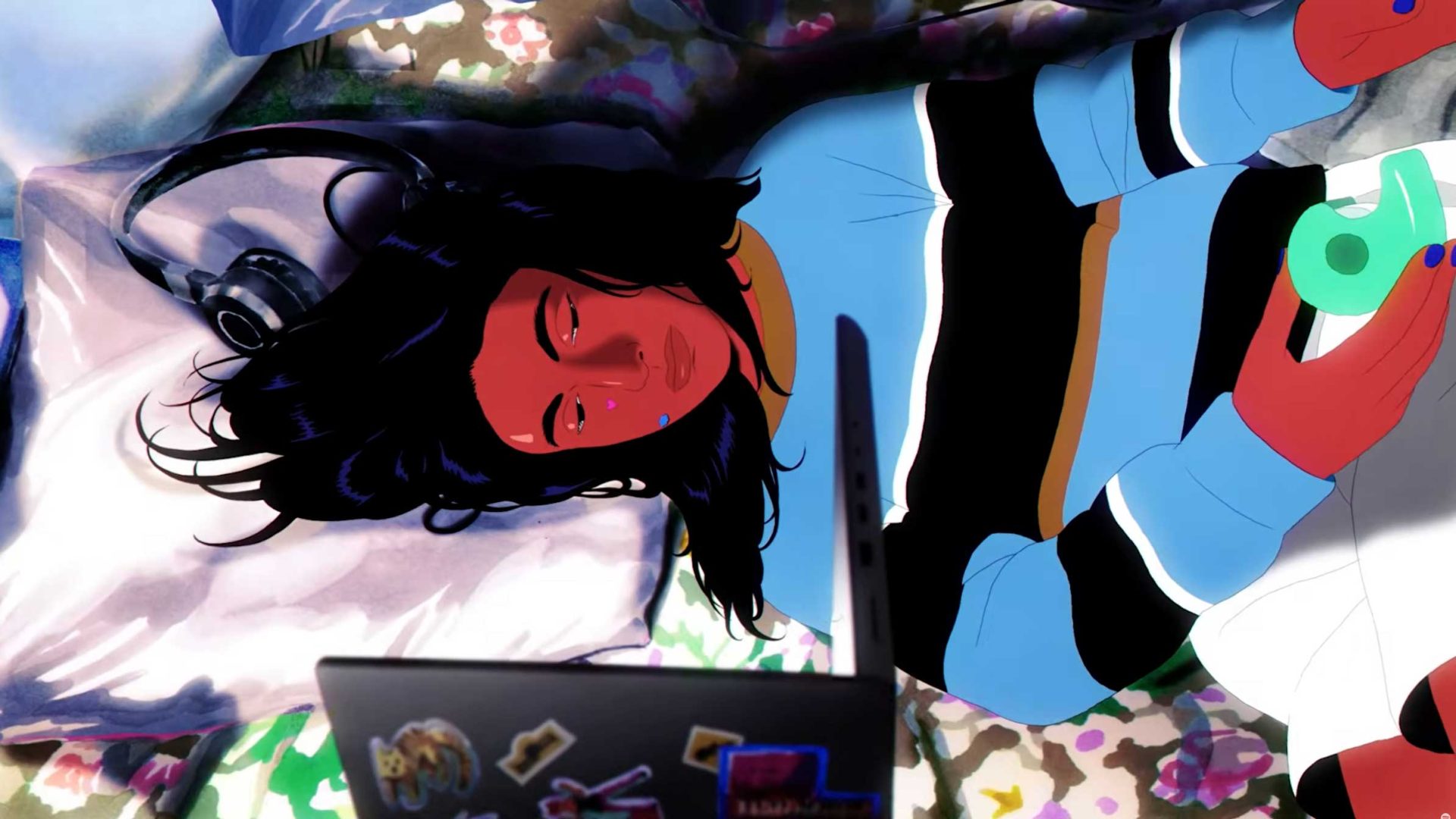 A person with long dark hair lies on a bed, wearing a striped sweater, looking at a laptop. Headphones rest nearby, and they hold a green game controller—a vibrant scene in the style of a Spotify Reserved animated ad by Jocelyn Charles. Frame from Stash Magazine article.
