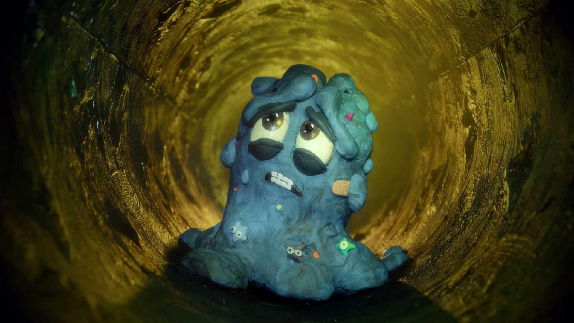 A sad blue clay blob with expressive eyes and a bandage sits in a dimly lit tunnel, looking up with a worried expression, reminiscent of the heartfelt characters seen in the SpringWell Walter’s Song commercial by Planet Super & Rich Zim. Frame from Stash Magazine article.