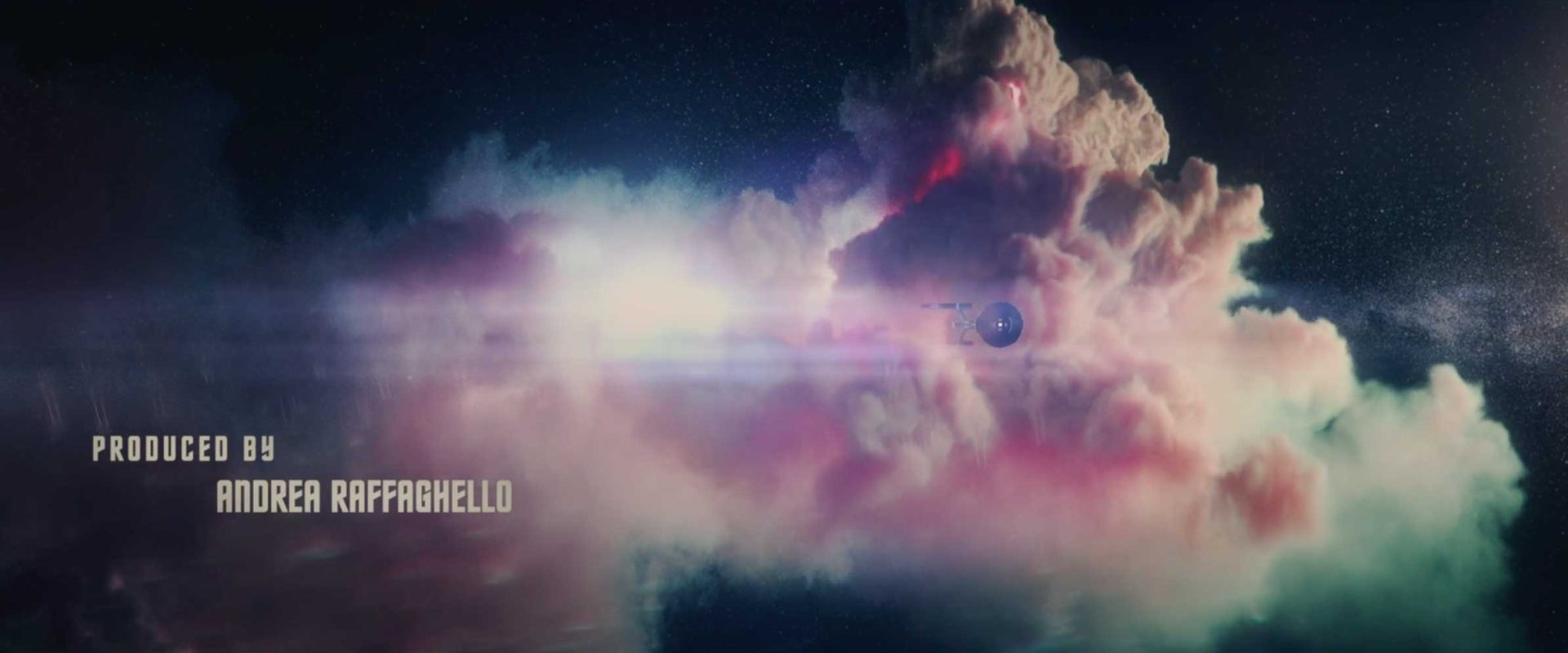 A spaceship flies through a colorful, glowing cloud in space, evoking the adventurous spirit of Star Trek: Strange New Worlds. The text Produced by Andrea Raffanello appears on the left side of the image. Frame from Stash Magazine article.