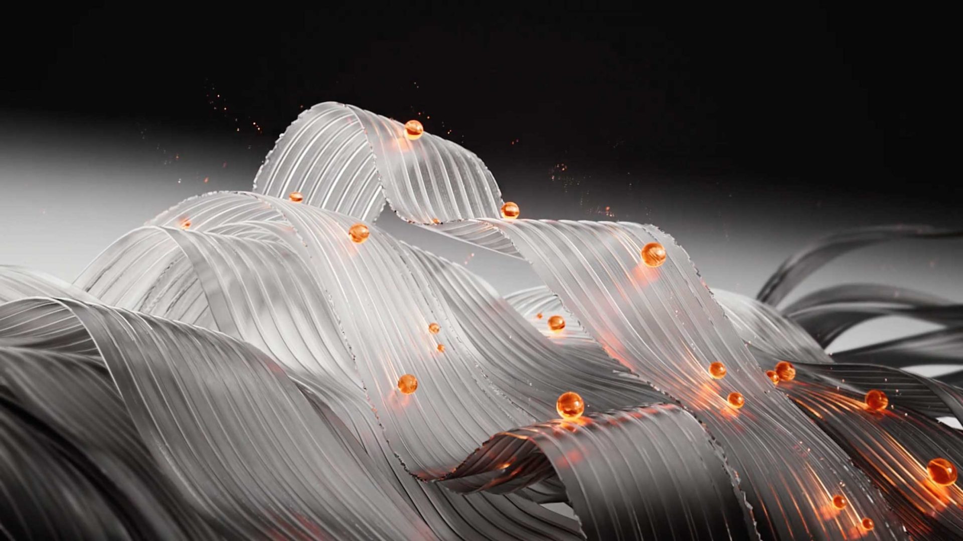 Wavy, reflective silver ribbons—sculpted as if by TRESemmé Professional expertise—intertwined and accented by small glowing orange spheres, set against a dark gradient background. Frame from Stash Magazine article.