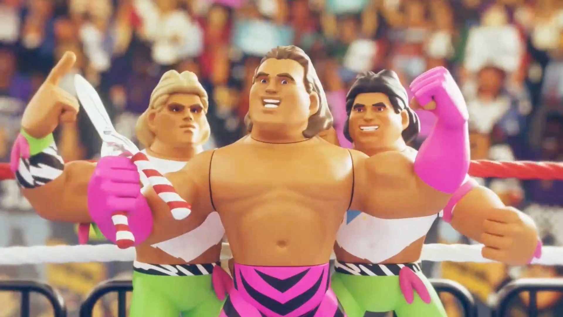 Three muscular wrestling action figures from the Golden Era of Wrestling stand in a ring—two in green pants, one blonde, one dark-haired, and a center figure in pink-striped tights holding scissors—with a lively crowd cheering for the next Body Slam. Frame from Stash Magazine article.