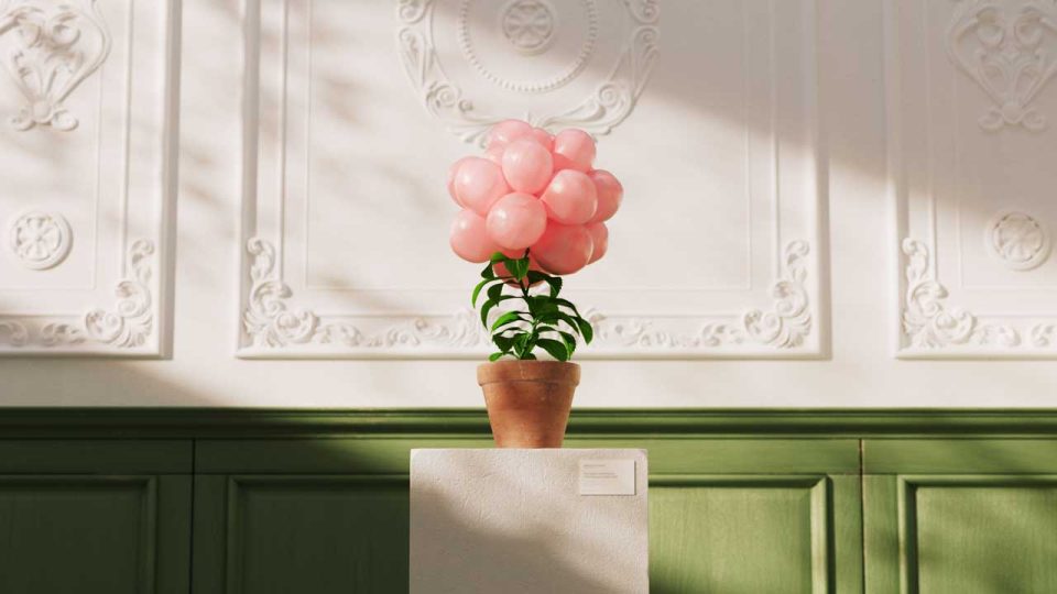 A potted plant with pink balloons arranged like a flower replaces the usual blooms, set on a pedestal against an ornate white and green wall—evoking the whimsical charm of The Sweet Performance of Bubblegum Plant short film by Sebastian Marek. Frame from Stash Magazine article.