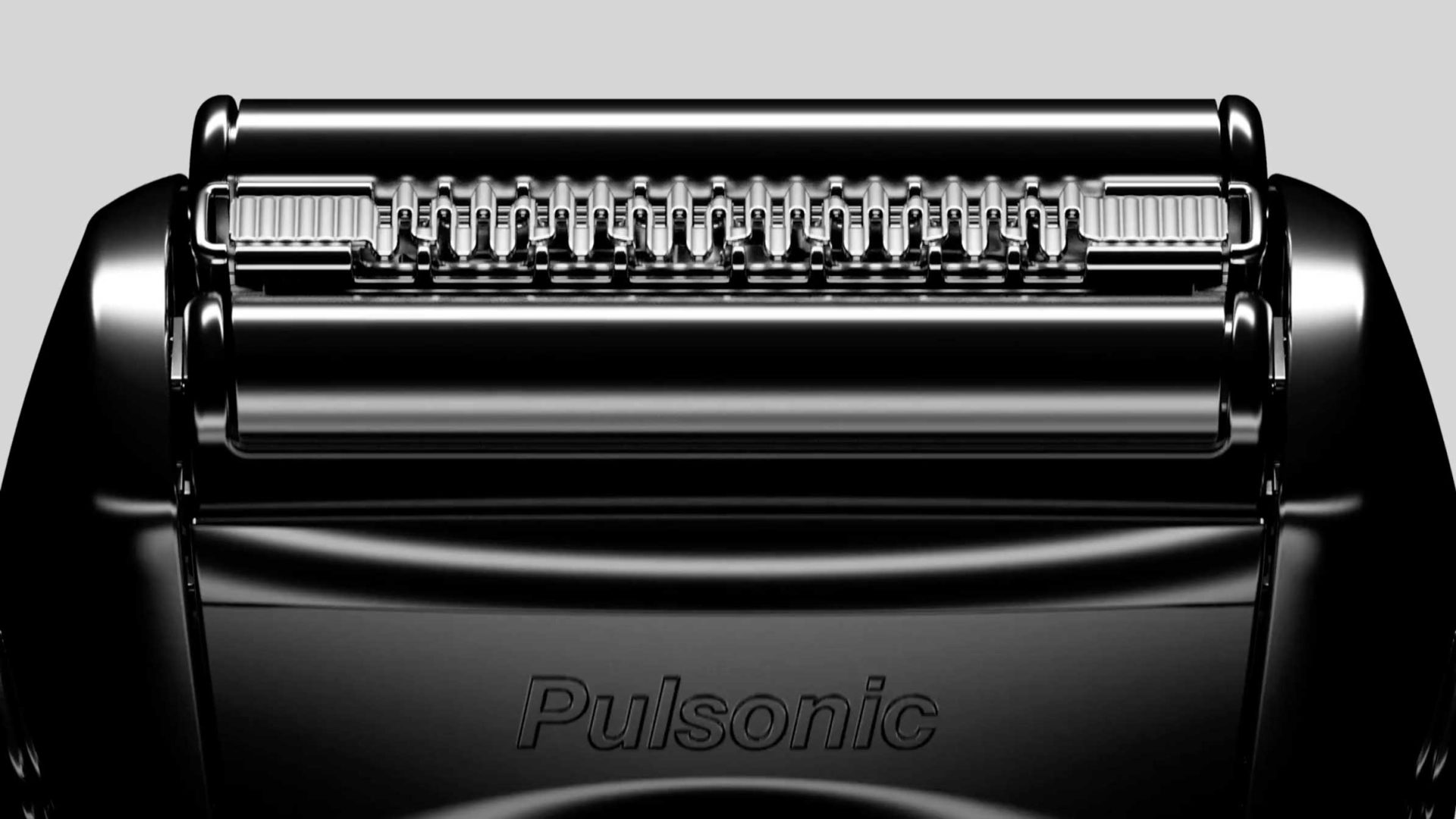 Close-up of a black Braun Series 7 electric shaver head with detailed blades and foil, featuring the brand name Pulsonic engraved on the casing. The background is light gray. Frame from Stash Magazine article.