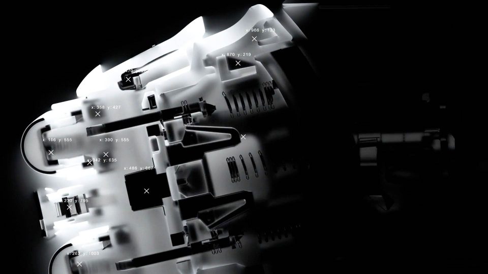 X-ray view of a complex mechanical device, possibly an engine or Braun Series 7 part, showing internal components and labeled coordinates marked with white numbers and X symbols against a black background. Frame from Stash Magazine article.