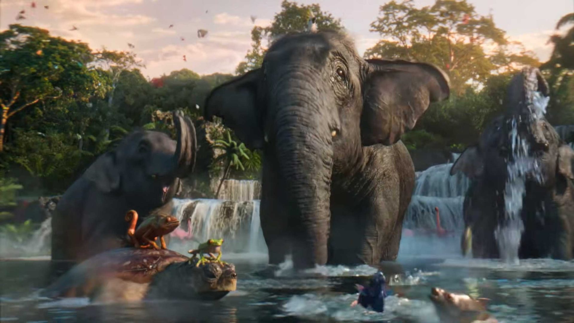Three elephants stand in a river near waterfalls and lush trees. Nearby, a turtle carries a monkey and frog on its shell, while a child swims toward the animals. Sunlight filters through this untold Tropicana scene, creating a magical atmosphere. Frame from Stash Magazine article.