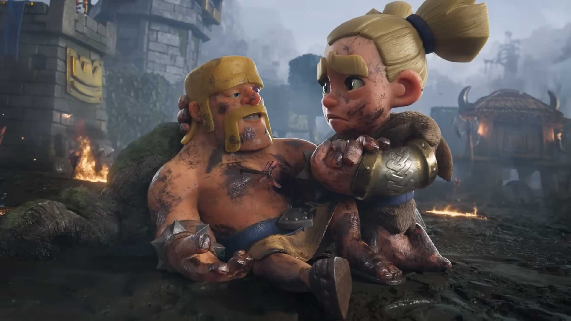 A muddy warrior sits injured on the ground, supported by a concerned blonde female fighter, in a battle-scarred, smoky village with damaged buildings and fires burning in the background—a scene reminiscent of an intense Clash Royale match where uncommon gizmos litter the battlefield amid chaos. Frame from Stash Magazine article.