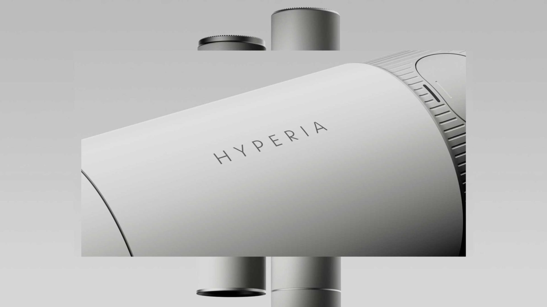 Close-up view of a sleek, modern device—the Hyperia Telescope by Vaonis—with HYPERIA printed on its smooth, white cylindrical surface; background features metallic elements and a minimalistic design fit for a launch film. Frame from Stash Magazine article.