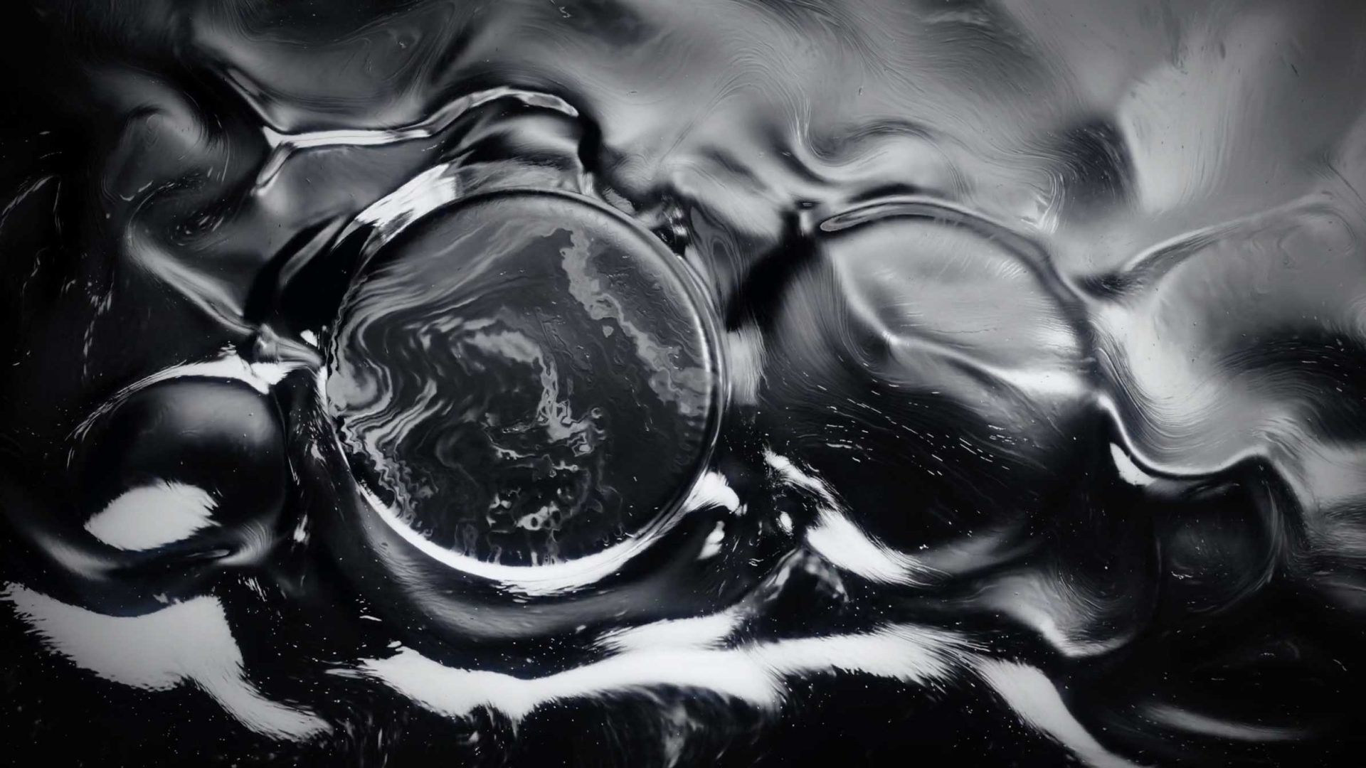 Abstract black-and-white image featuring swirling, fluid patterns with two prominent circular shapes at the center and right, evoking the ethereal visuals seen in the Vaonis Hyperia Telescope Launch Film. Frame from Stash Magazine article.